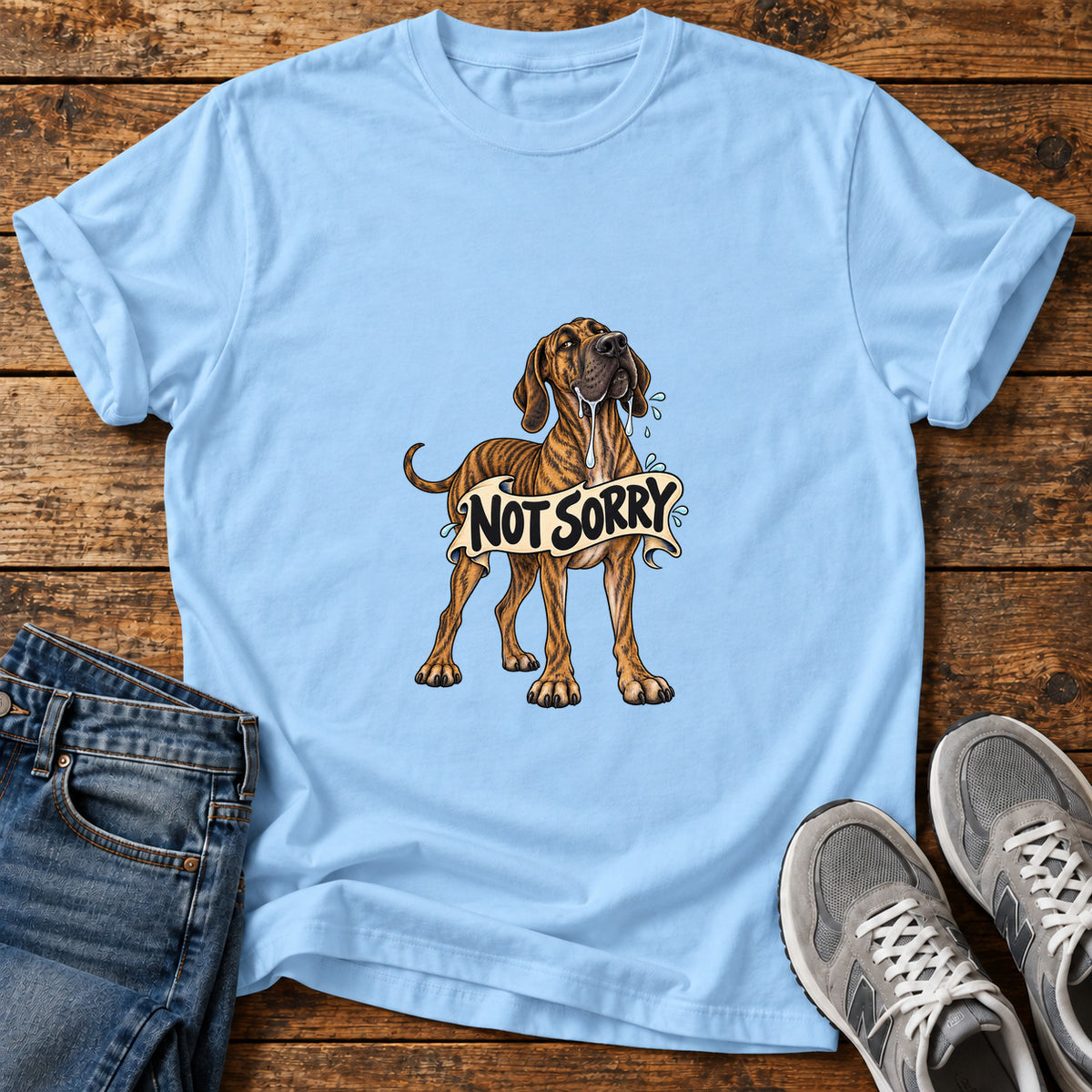 Not Sorry Great Dane graphic T-shirt in Light Blue, shown on a flat-lay shirt mockup