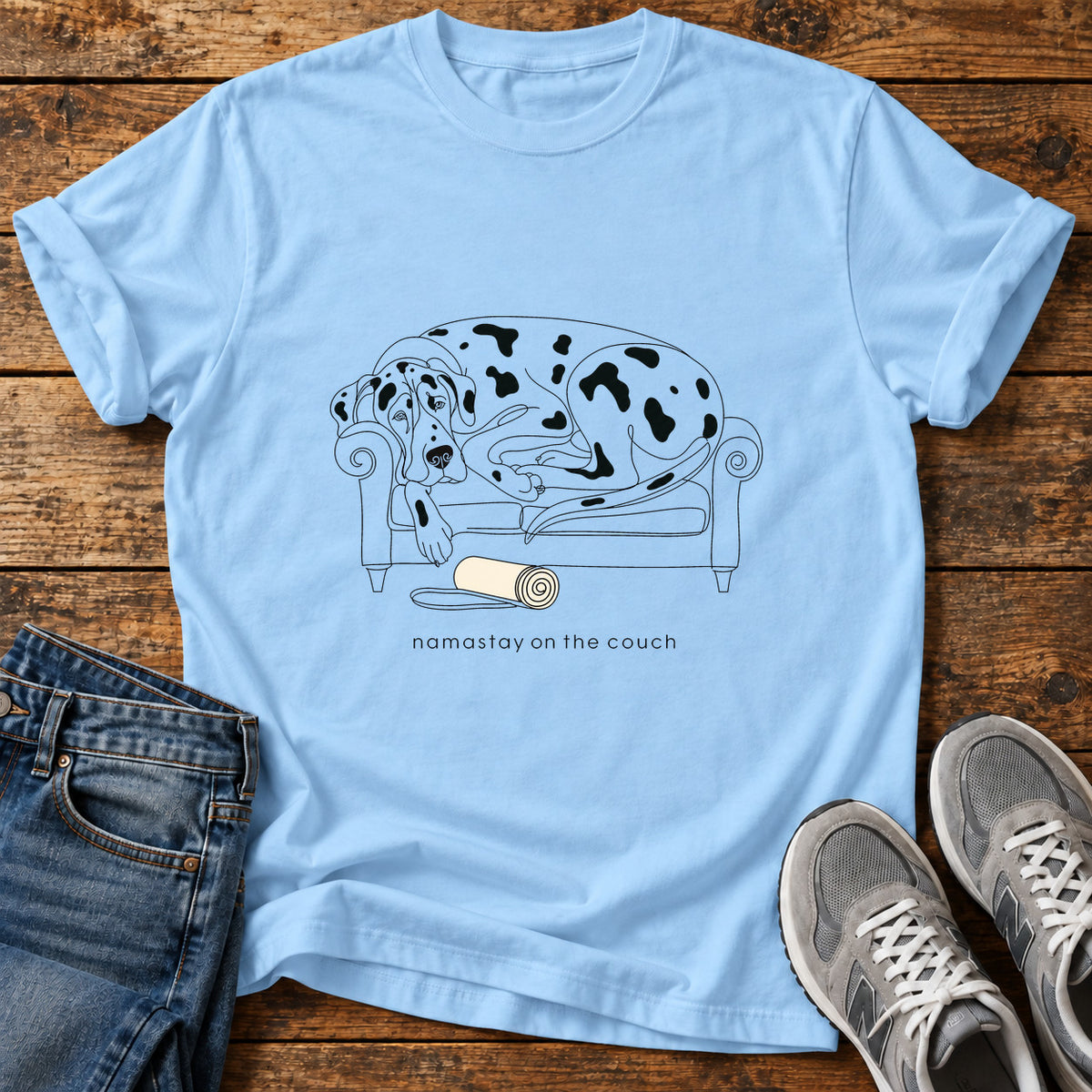 Namastay Couch Great Dane graphic T-shirt in Light Blue, shown on a flat-lay shirt mockup