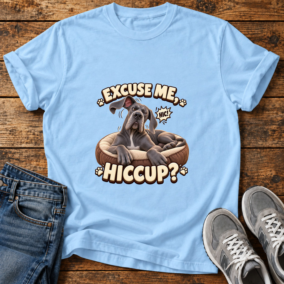 Excuse Hiccup Great Dane graphic T-shirt in Light Blue, shown on a flat-lay shirt mockup