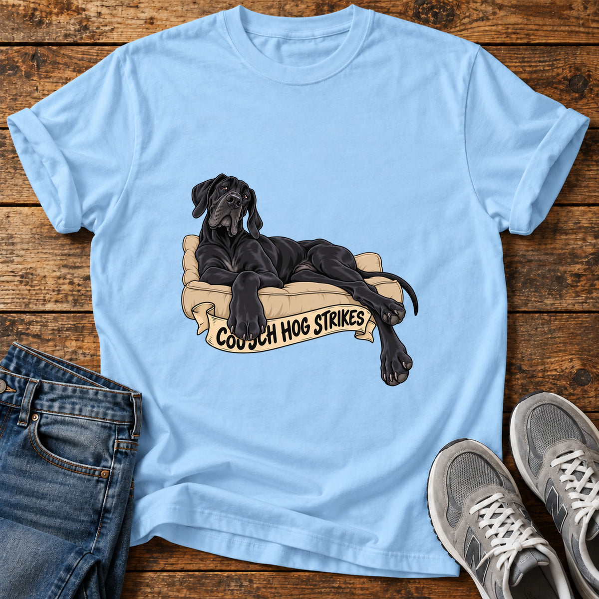 Couch Hog Strikes Great Dane graphic T-shirt in Light Blue, shown on a flat-lay shirt mockup