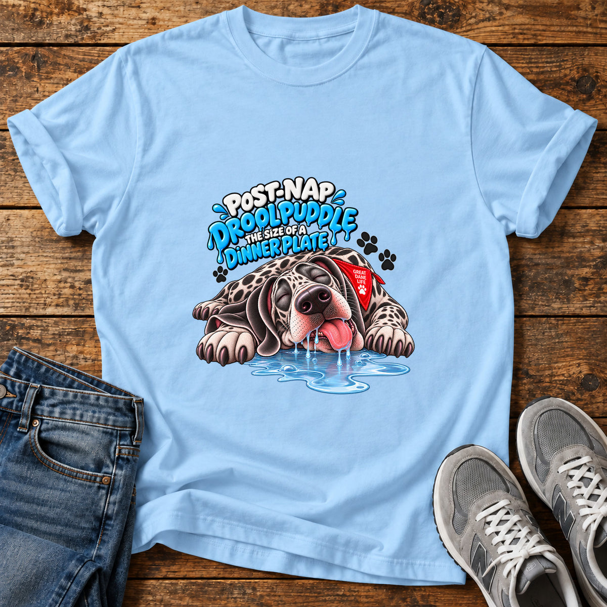 Drool Puddle Dog Great Dane graphic T-shirt in Light Blue, shown on a flat-lay shirt mockup