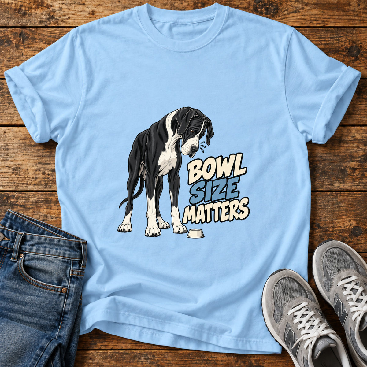 Bowl Size Matters Great Dane graphic T-shirt in Light Blue, shown on a flat-lay shirt mockup