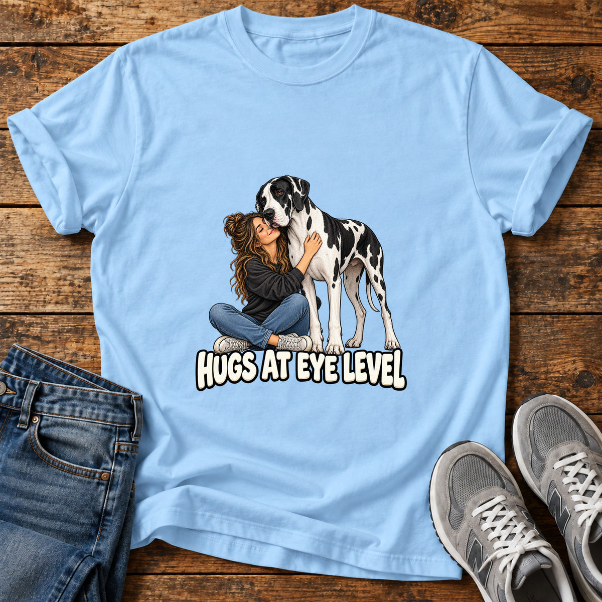 Hugs At Eye Great Dane graphic T-shirt in Light Blue, shown on a flat-lay shirt mockup