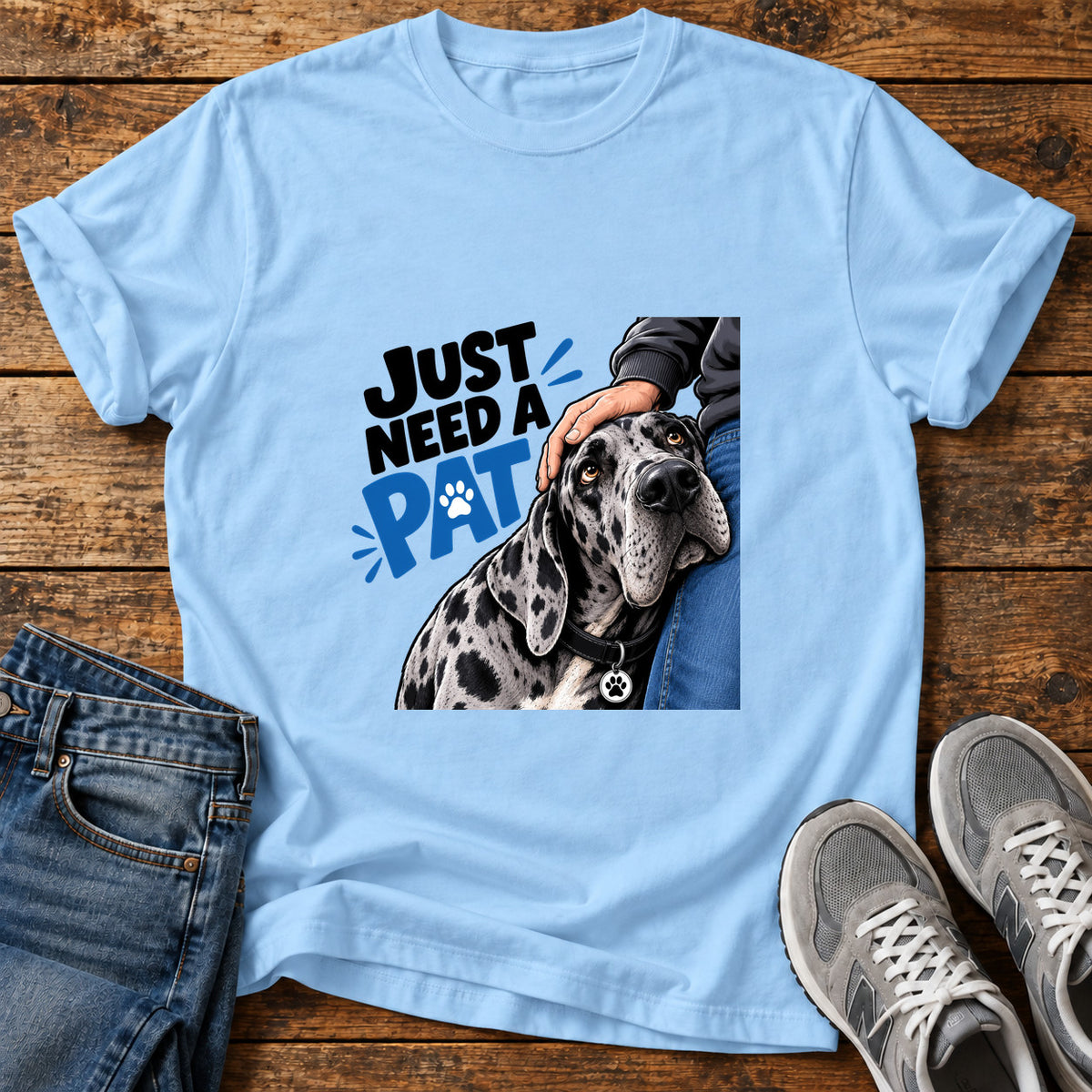 Just Need Pat Great Dane graphic T-shirt in Light Blue, shown on a flat-lay shirt mockup