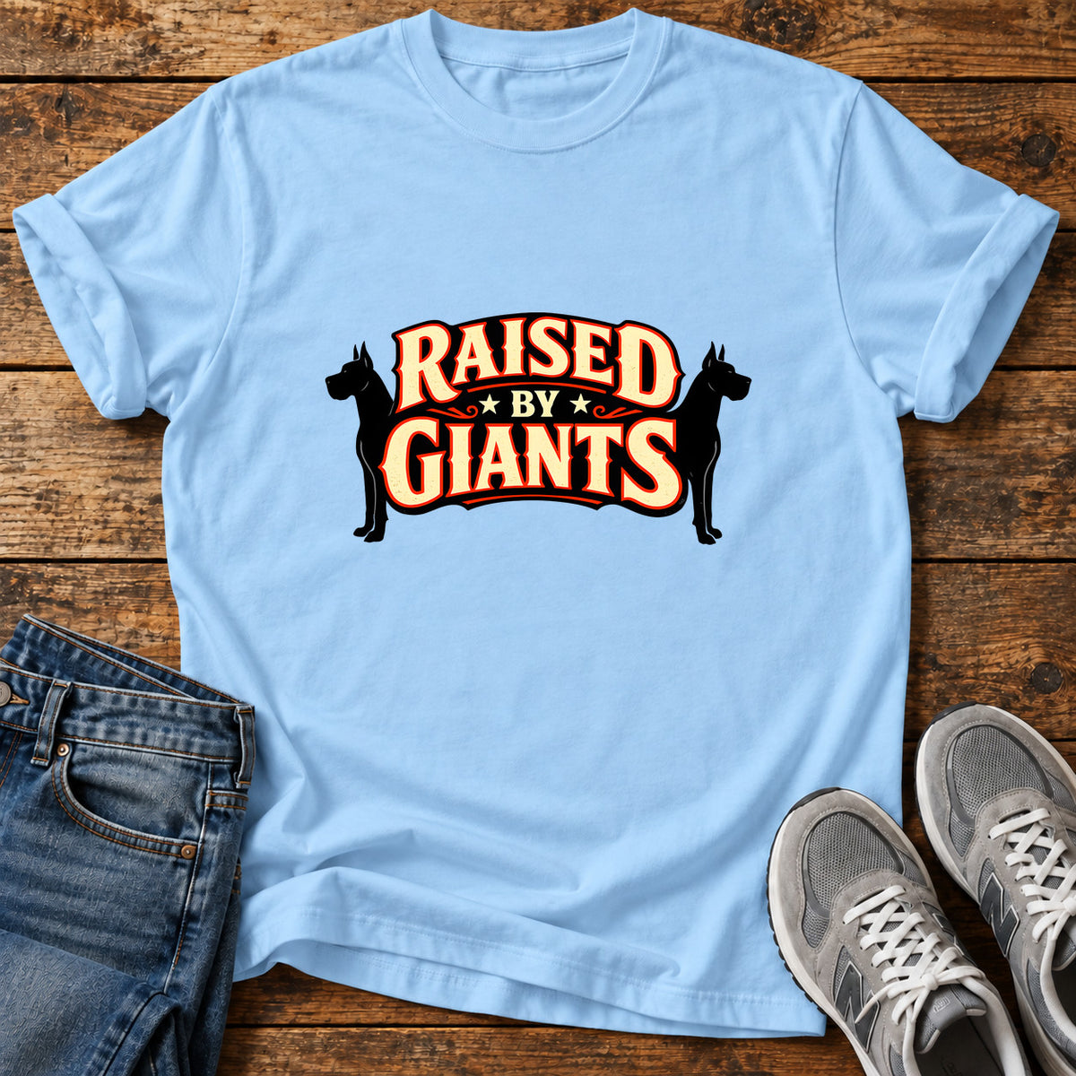 Raised By Giants Great Dane graphic T-shirt in Light Blue, shown on a flat-lay shirt mockup