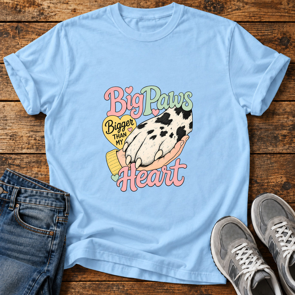 Big Paws Heart Great Dane graphic T-shirt in Light Blue, shown on a flat-lay shirt mockup