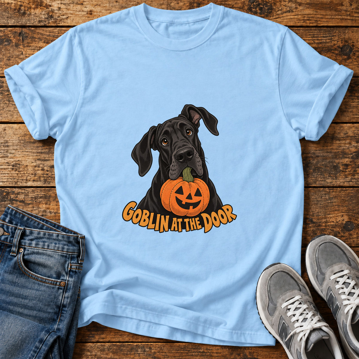 Goblin At Door Great Dane graphic T-shirt in Light Blue, shown on a flat-lay shirt mockup