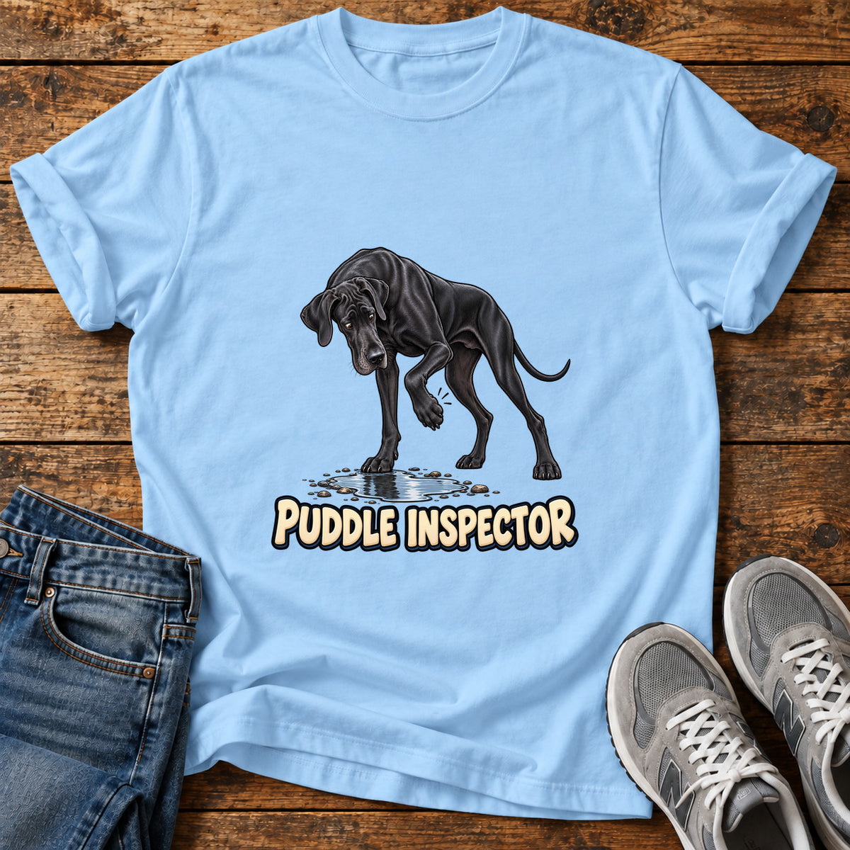 Puddle Inspector Great Dane graphic T-shirt in Light Blue, shown on a flat-lay shirt mockup