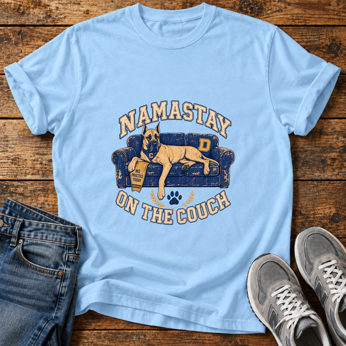 Namastay Couch Great Dane graphic T-shirt in Light Blue, shown on a flat-lay shirt mockup