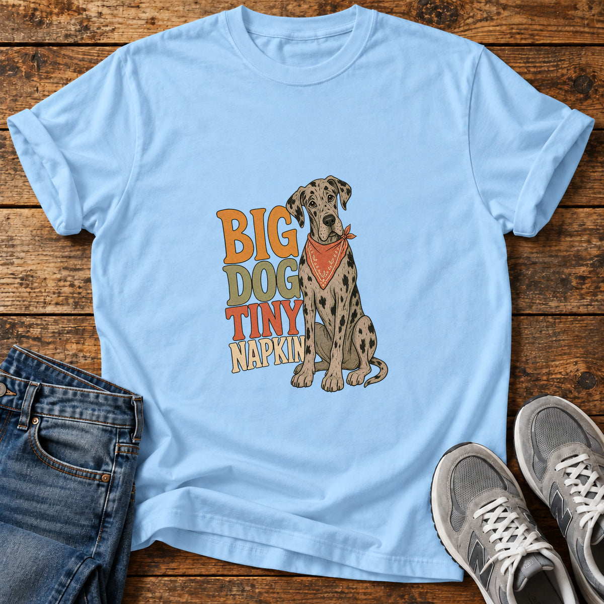 Big Dog Napkin Great Dane graphic T-shirt in Light Blue, shown on a flat-lay shirt mockup