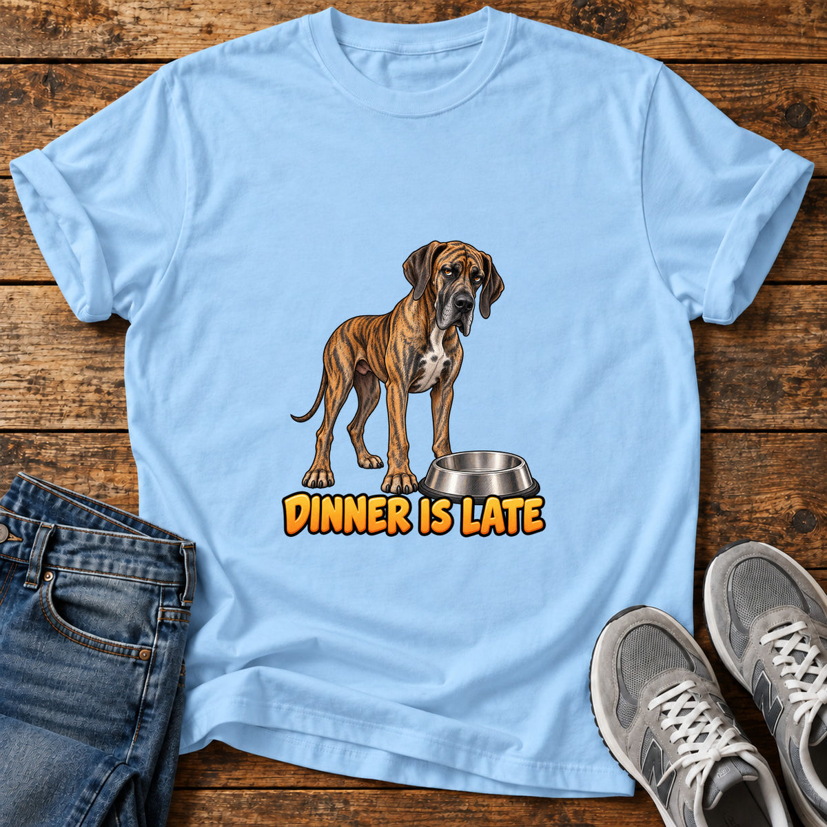 Dinner Is Late Great Dane graphic T-shirt in Light Blue, shown on a flat-lay shirt mockup