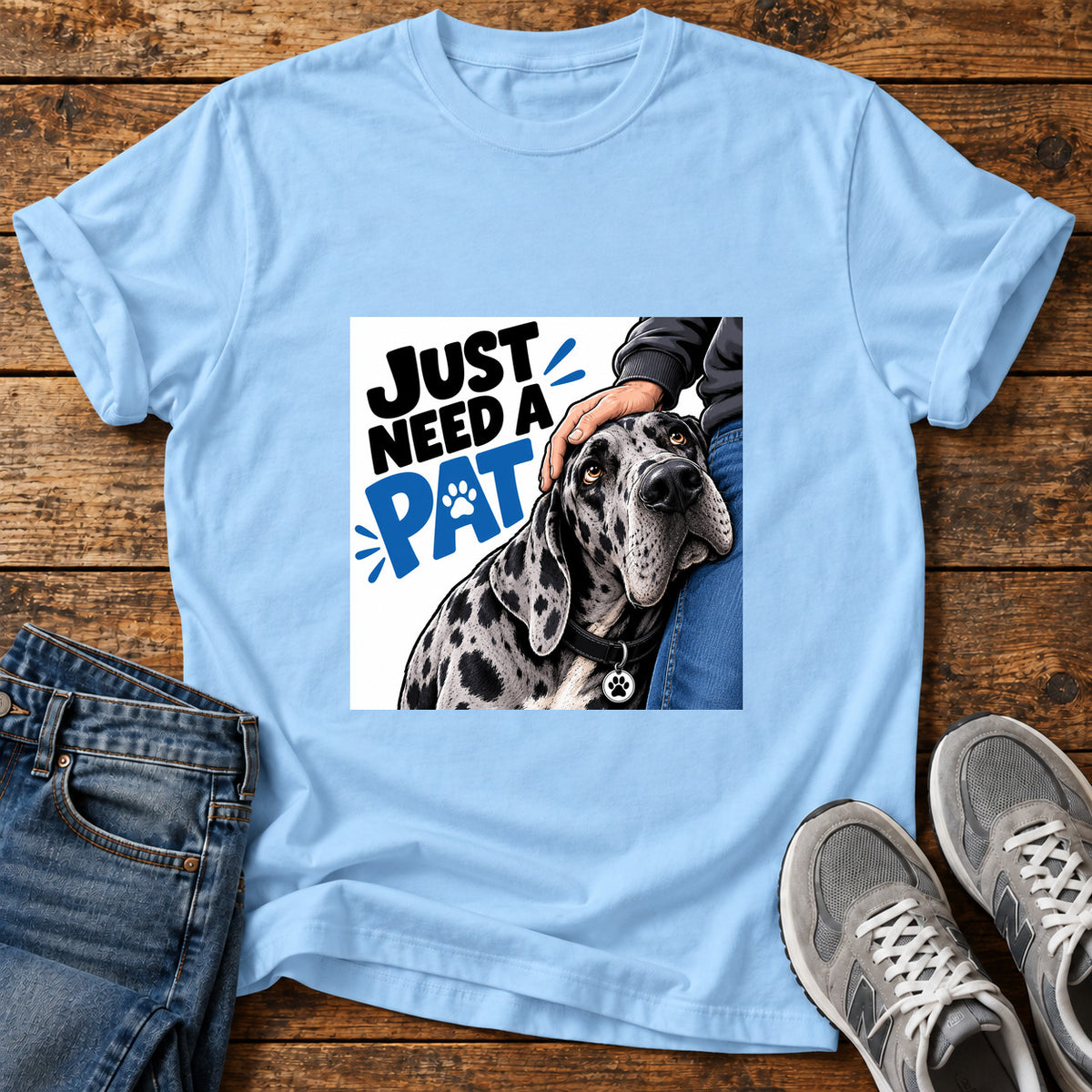 Just Need Pat Great Dane graphic T-shirt in Light Blue, shown on a flat-lay shirt mockup
