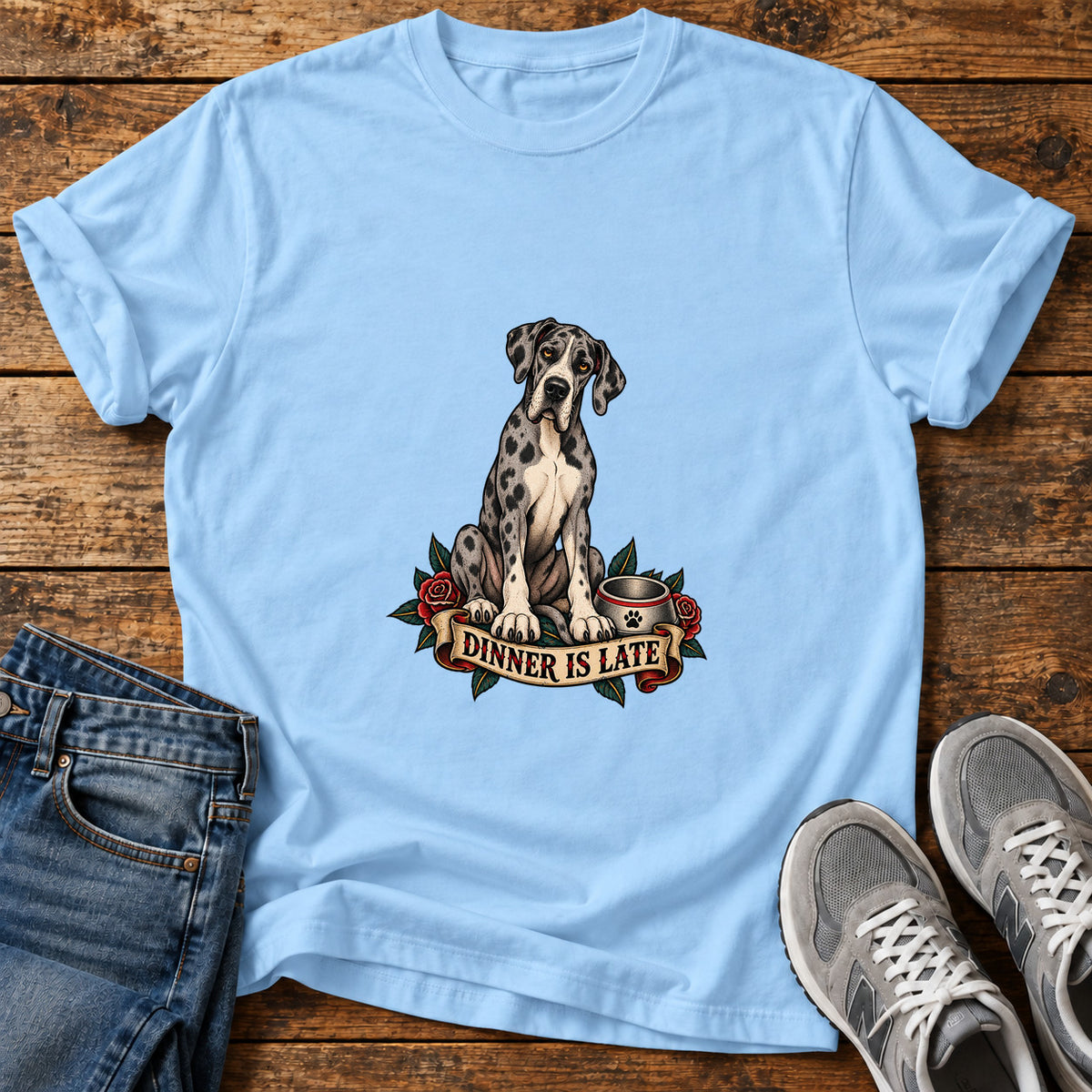 Dinner Is Late Great Dane graphic T-shirt in Light Blue, shown on a flat-lay shirt mockup