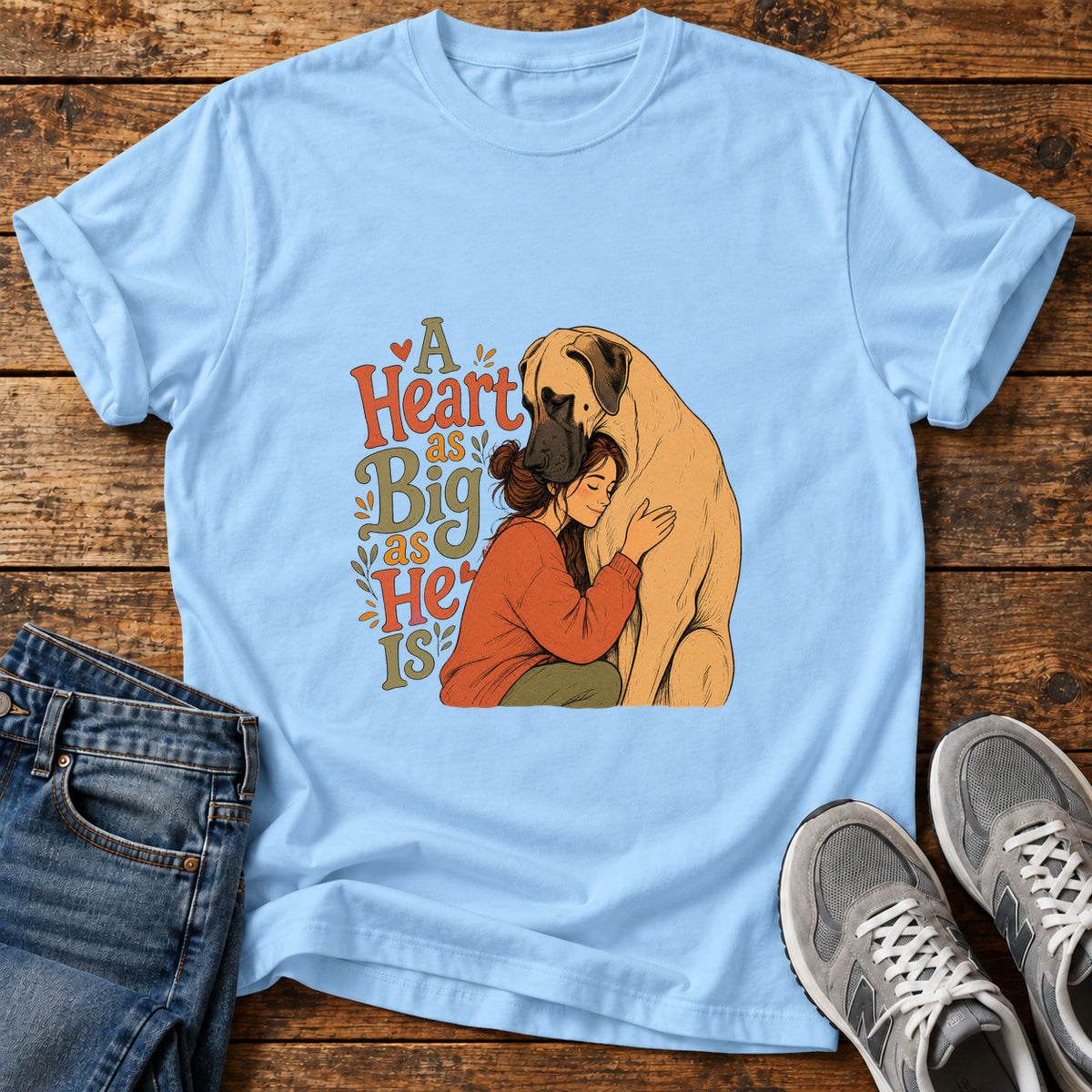 A Heartful Hug Great Dane graphic T-shirt in Light Blue, shown on a flat-lay shirt mockup