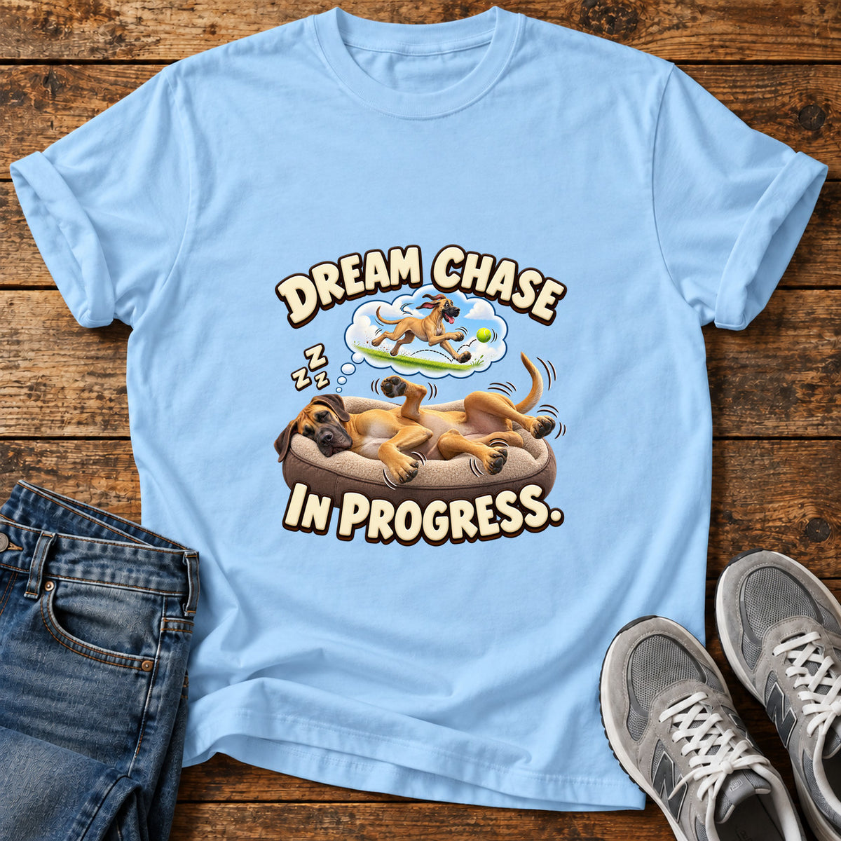Dream Chase Progress Great Dane graphic T-shirt in Light Blue, shown on a flat-lay shirt mockup
