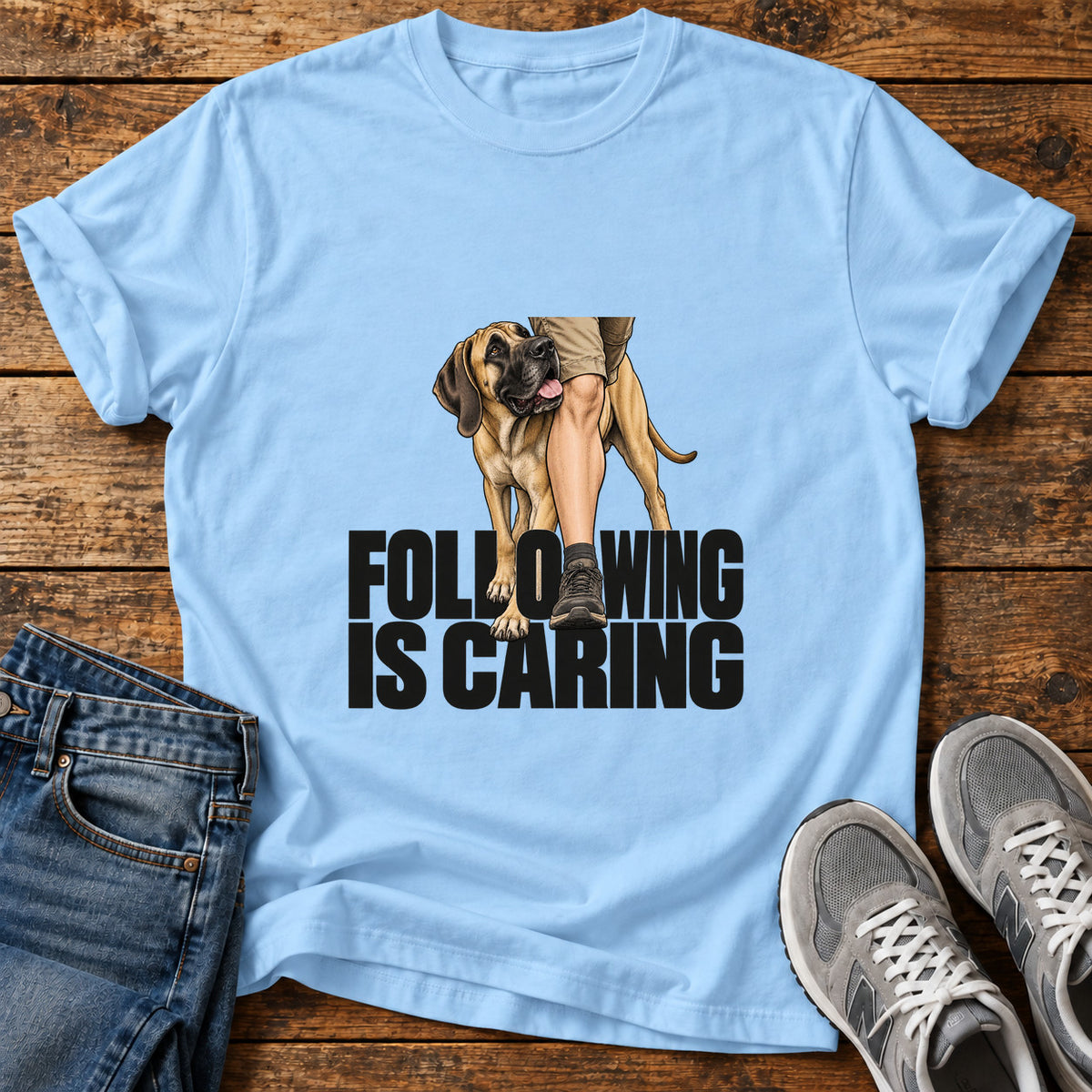 Following Is Caring Great Dane graphic T-shirt in Light Blue, shown on a flat-lay shirt mockup