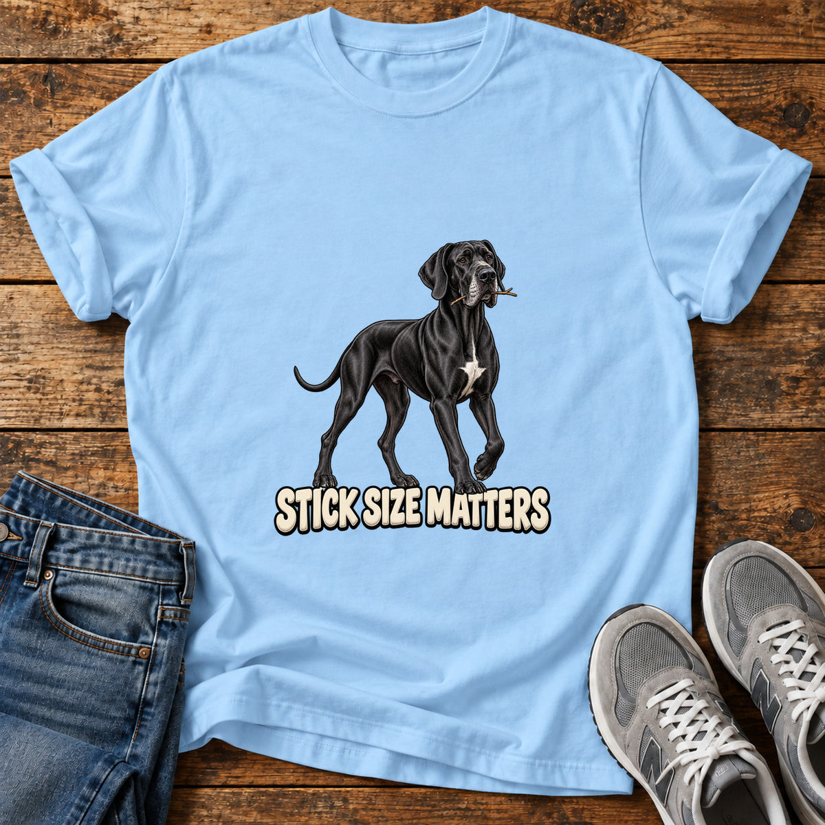 Stick Size Matters Great Dane graphic T-shirt in Light Blue, shown on a flat-lay shirt mockup
