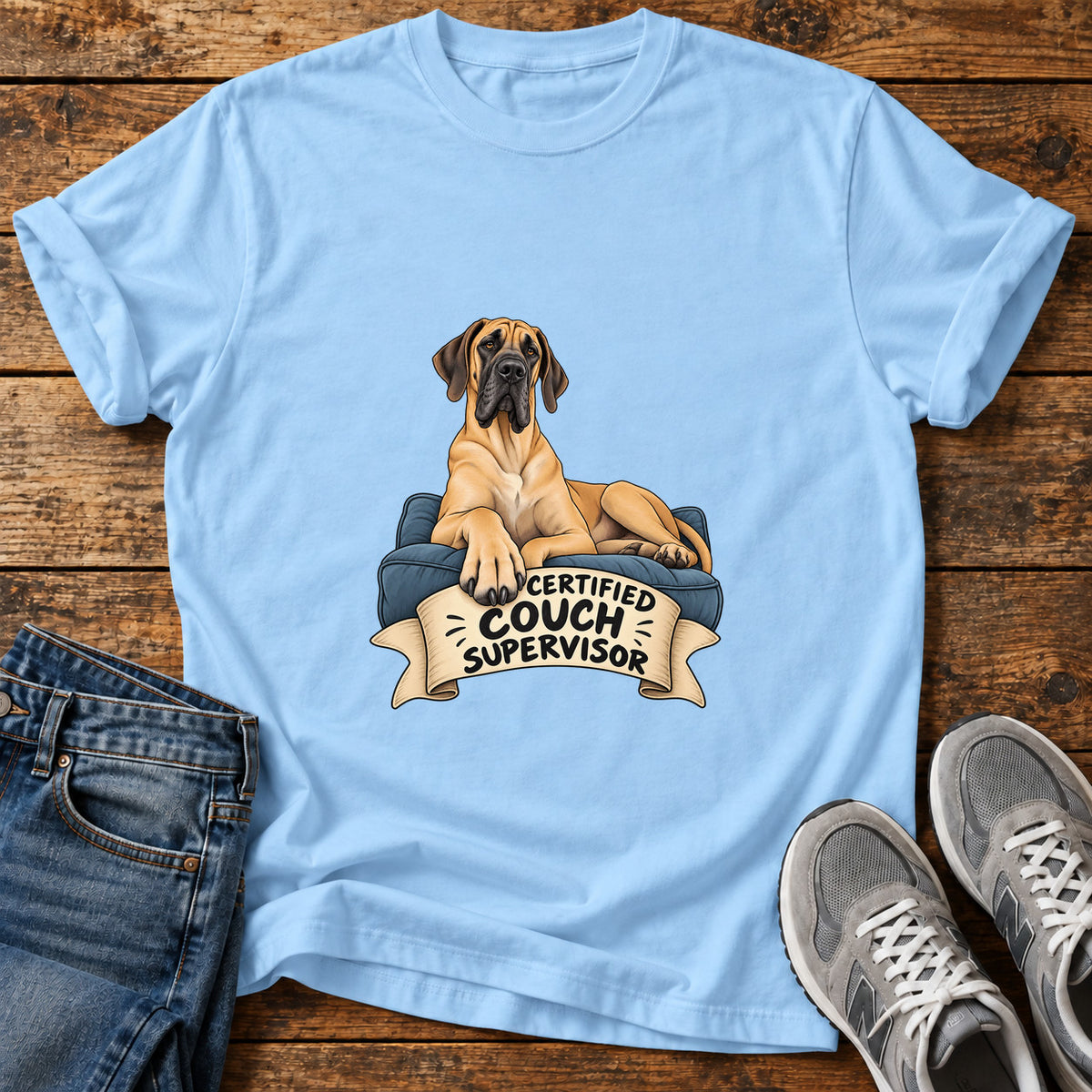 Certified Couch Supervisor Great Dane graphic T-shirt in Light Blue, shown on a flat-lay shirt mockup