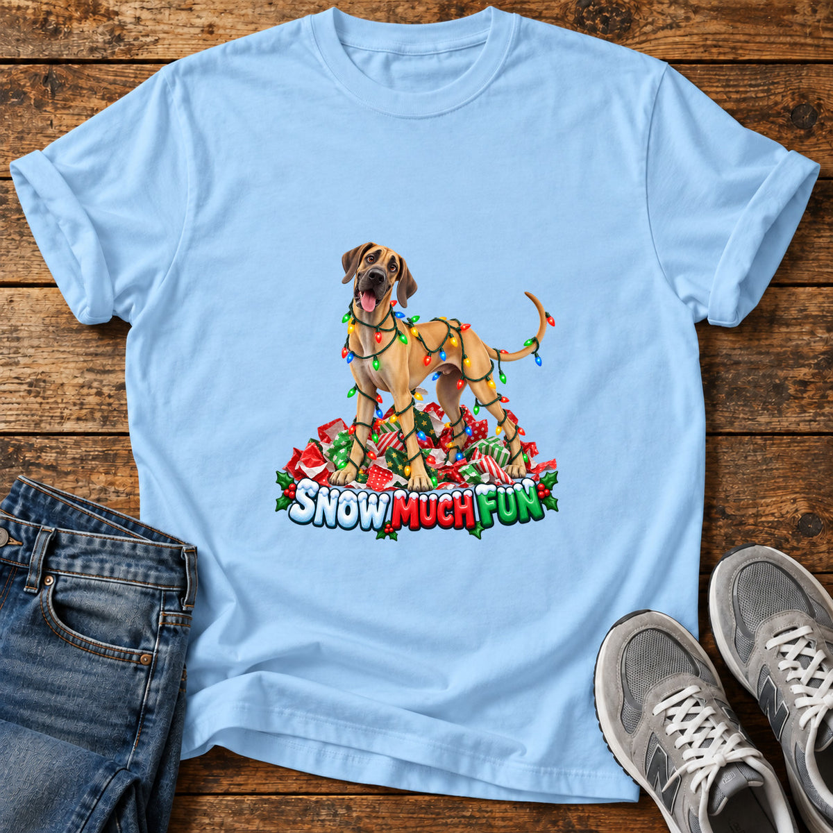 Snow Much Fun Great Dane graphic T-shirt in Light Blue, shown on a flat-lay shirt mockup