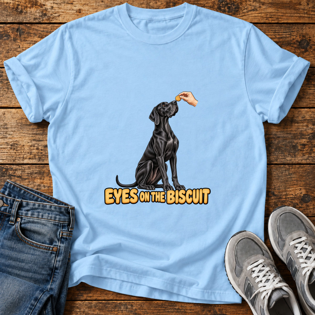 Eyes on Biscuit Great Dane graphic T-shirt in Light Blue, shown on a flat-lay shirt mockup