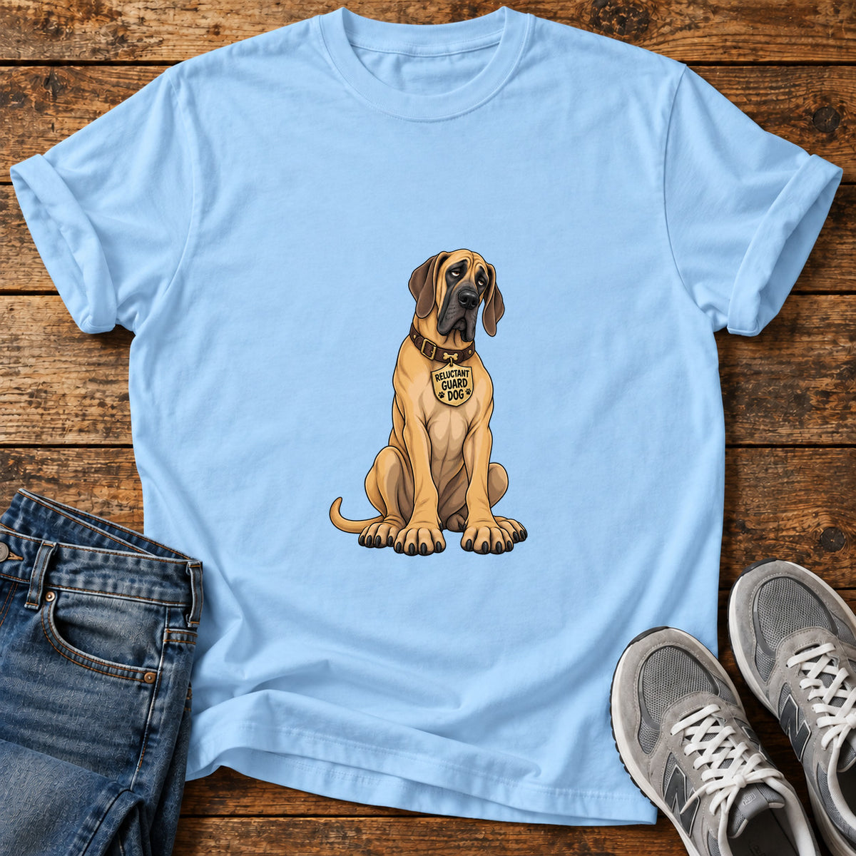 Reluctant Guard Dog Great Dane graphic T-shirt in Light Blue, shown on a flat-lay shirt mockup