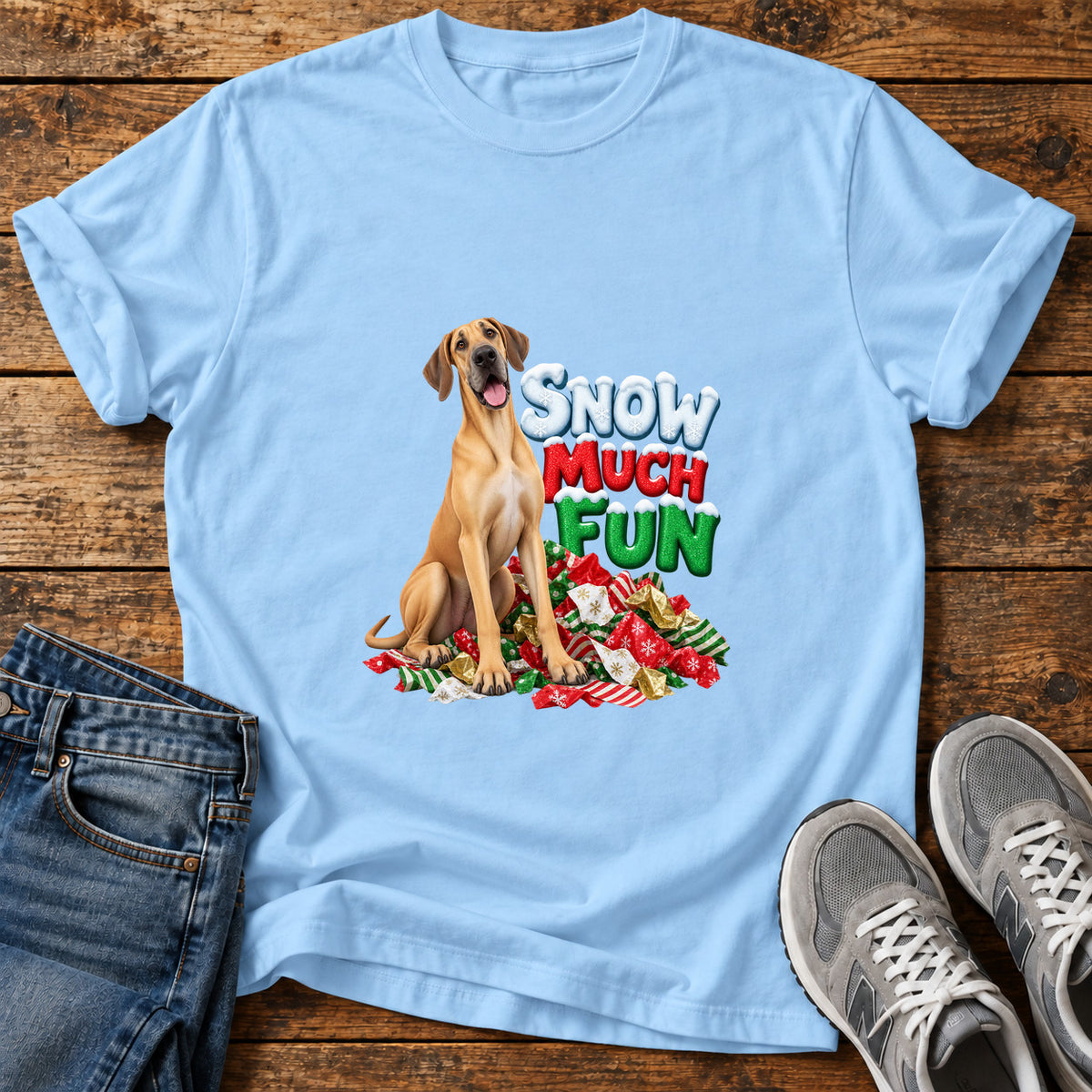 Snow Much Fun Great Dane graphic T-shirt in Light Blue, shown on a flat-lay shirt mockup