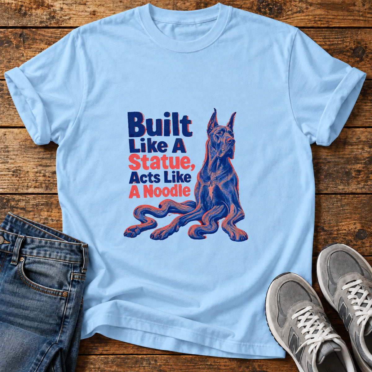 Statue Noodle Great Dane graphic T-shirt in Light Blue, shown on a flat-lay shirt mockup