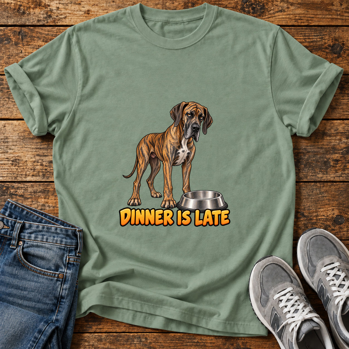 Dinner Is Late Great Dane graphic T-shirt in Sage, shown on a flat-lay shirt mockup