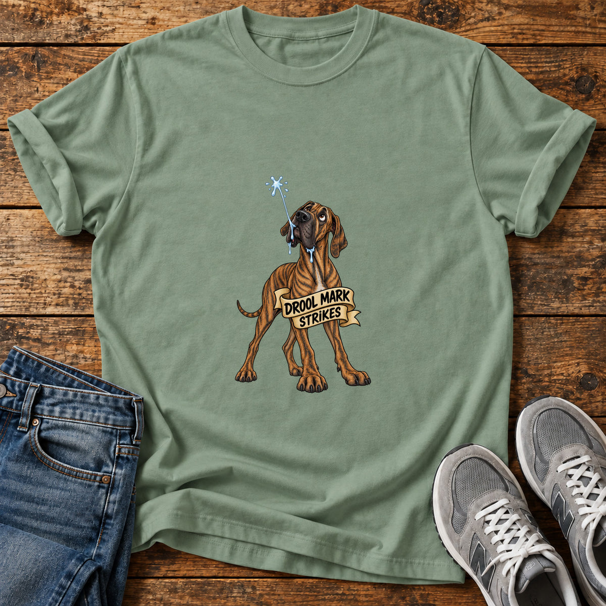 Drool Mark Strikes Great Dane graphic T-shirt in Sage, shown on a flat-lay shirt mockup