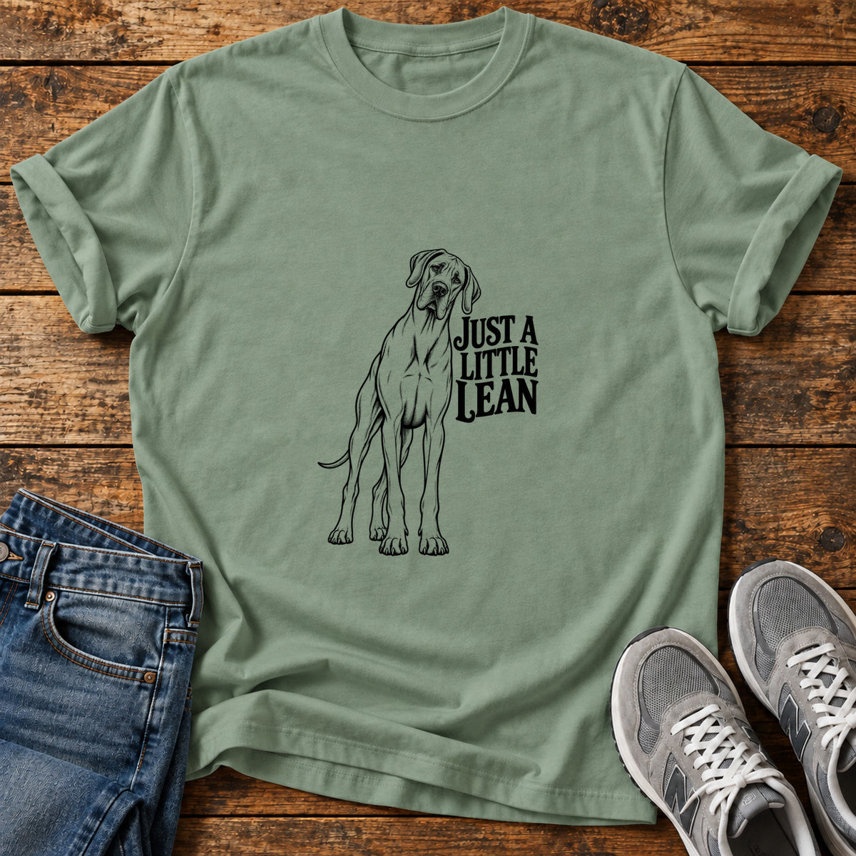 Just A Lean Great Dane graphic T-shirt in Sage, shown on a flat-lay shirt mockup