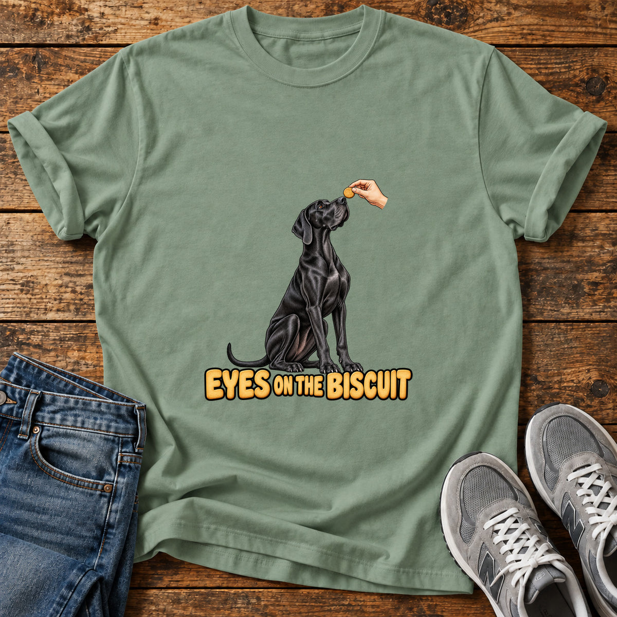Eyes on Biscuit Great Dane graphic T-shirt in Sage, shown on a flat-lay shirt mockup