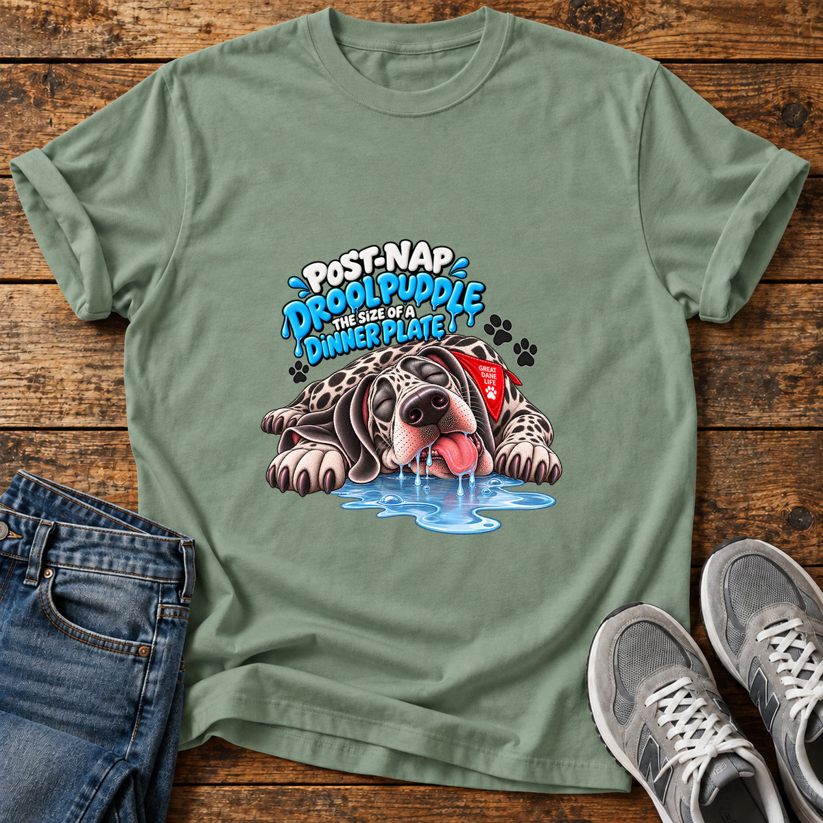 Drool Puddle Delight Great Dane graphic T-shirt in Sage, shown on a flat-lay shirt mockup