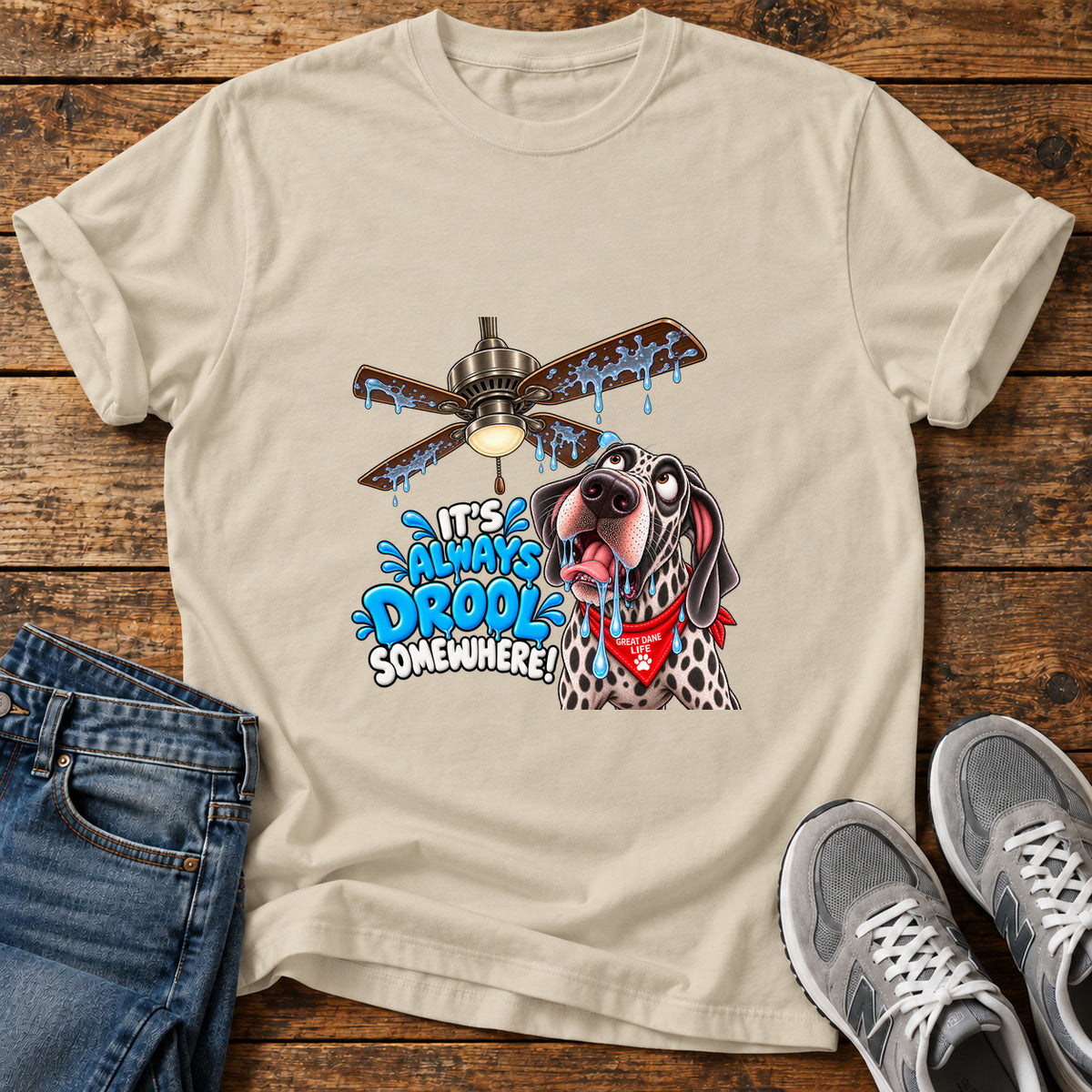 Drool Everywhere Great Dane graphic T-shirt in Sand, shown on a flat-lay shirt mockup