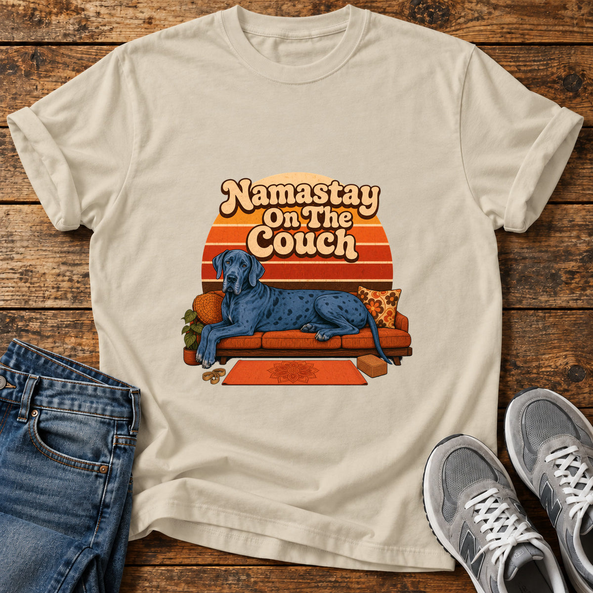 Namastay Couch Pooch Great Dane graphic T-shirt in Sand, shown on a flat-lay shirt mockup
