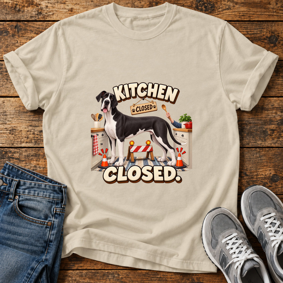 Kitchen Closed Great Dane graphic T-shirt in Sand, shown on a flat-lay shirt mockup