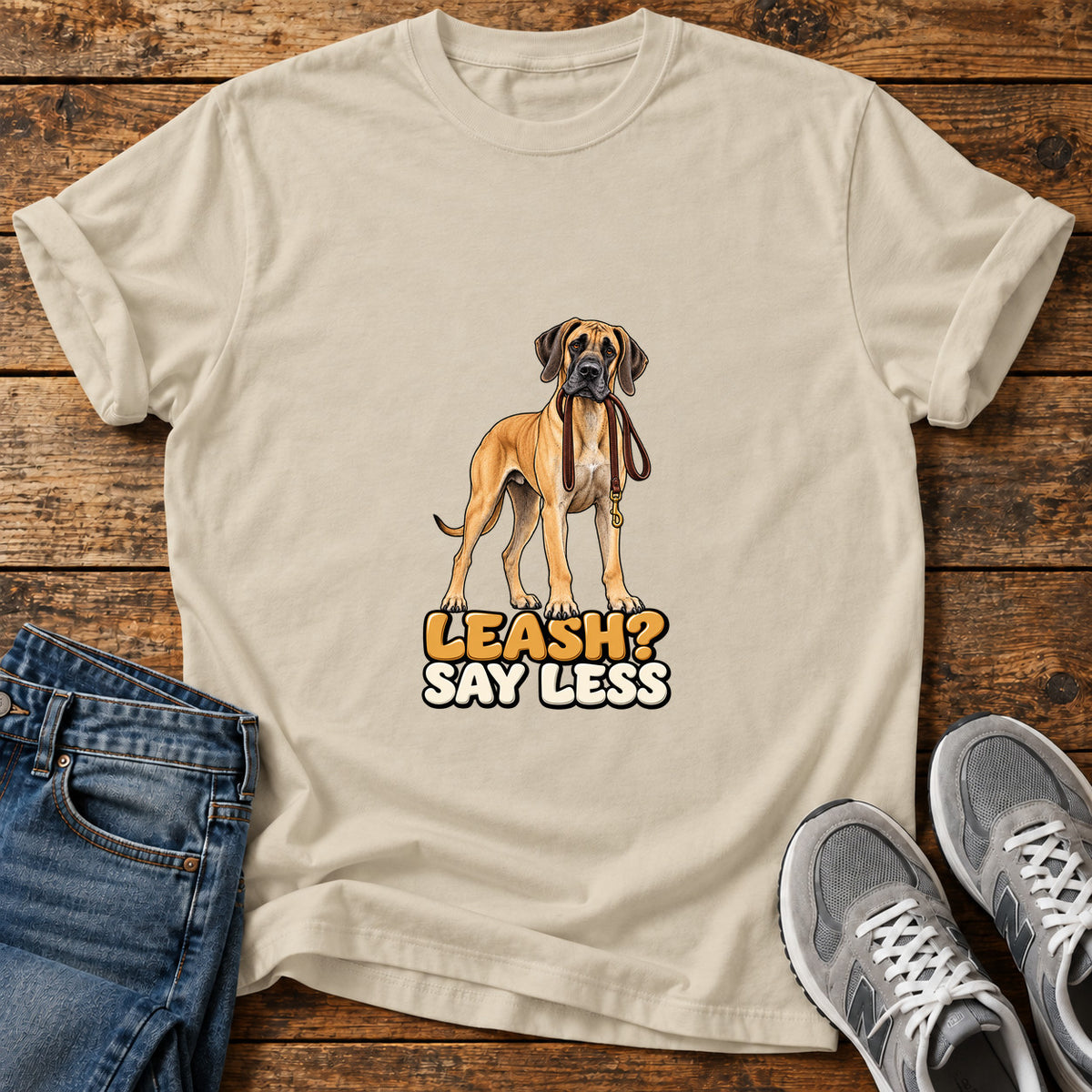Leash Say Less Great Dane graphic T-shirt in Sand, shown on a flat-lay shirt mockup