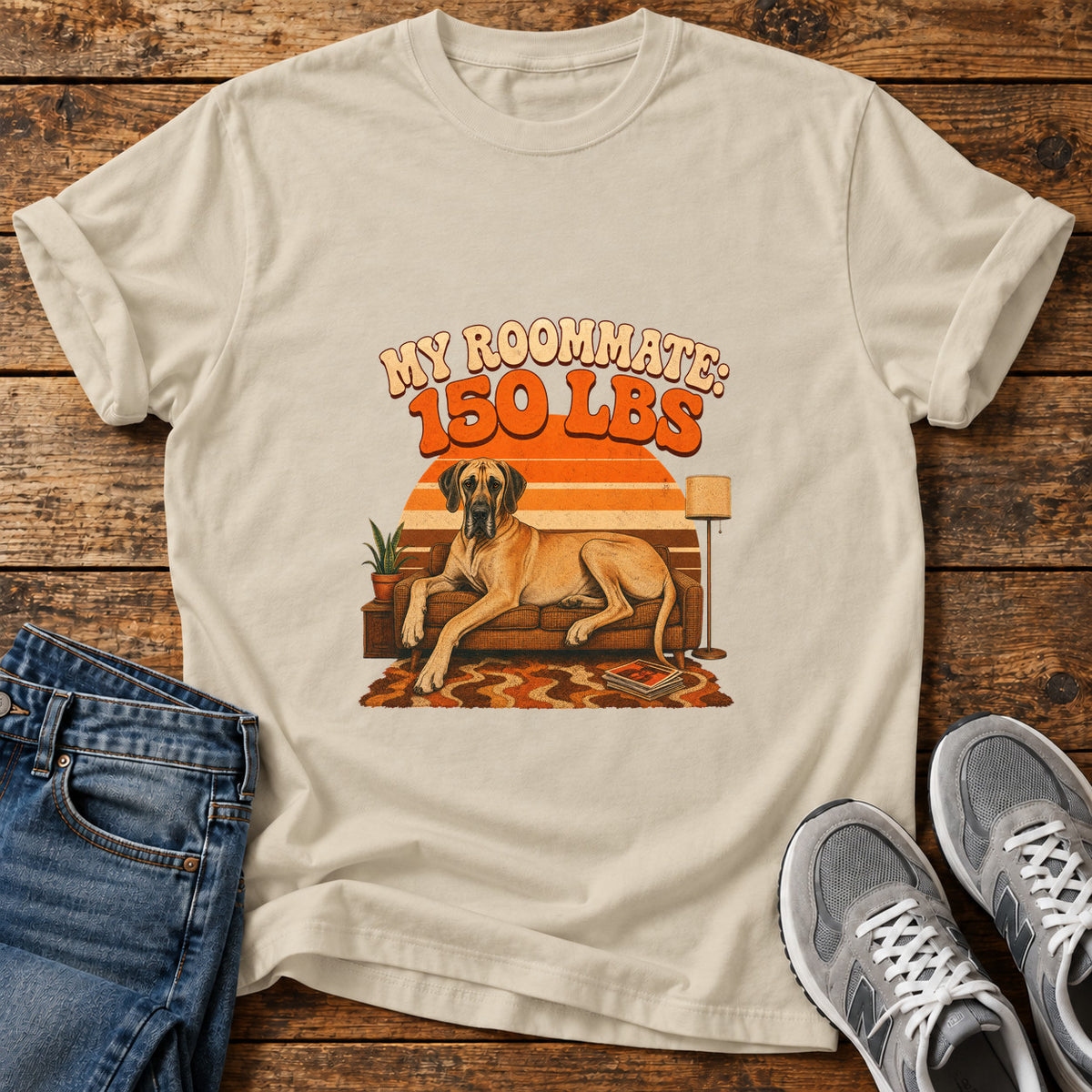 Roommate 150lbs Great Dane graphic T-shirt in Sand, shown on a flat-lay shirt mockup
