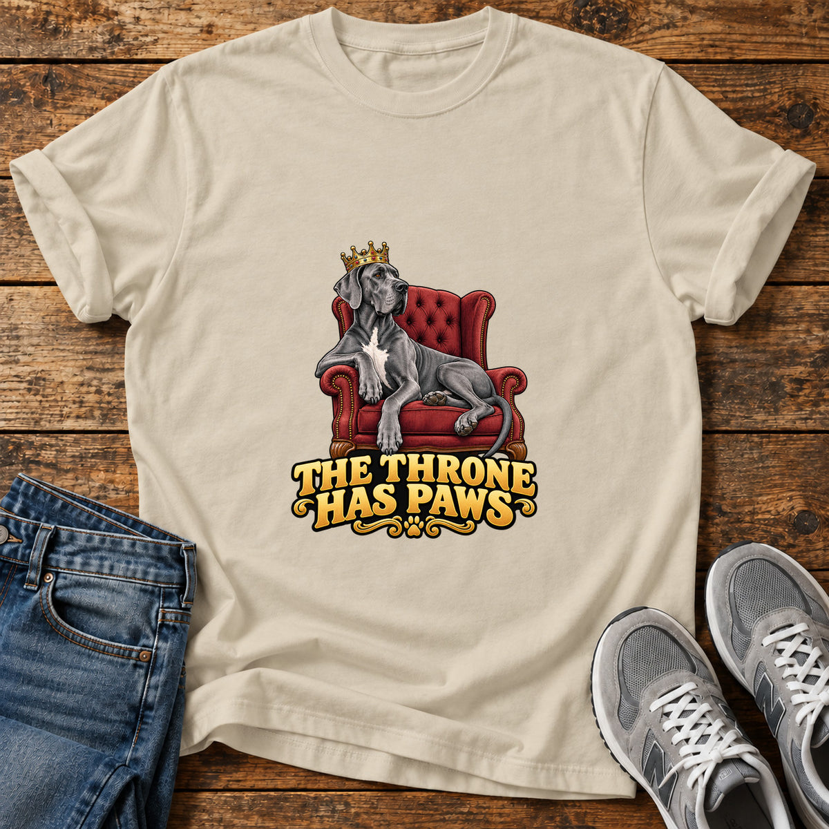 Throne Paws Majesty Great Dane graphic T-shirt in Sand, shown on a flat-lay shirt mockup