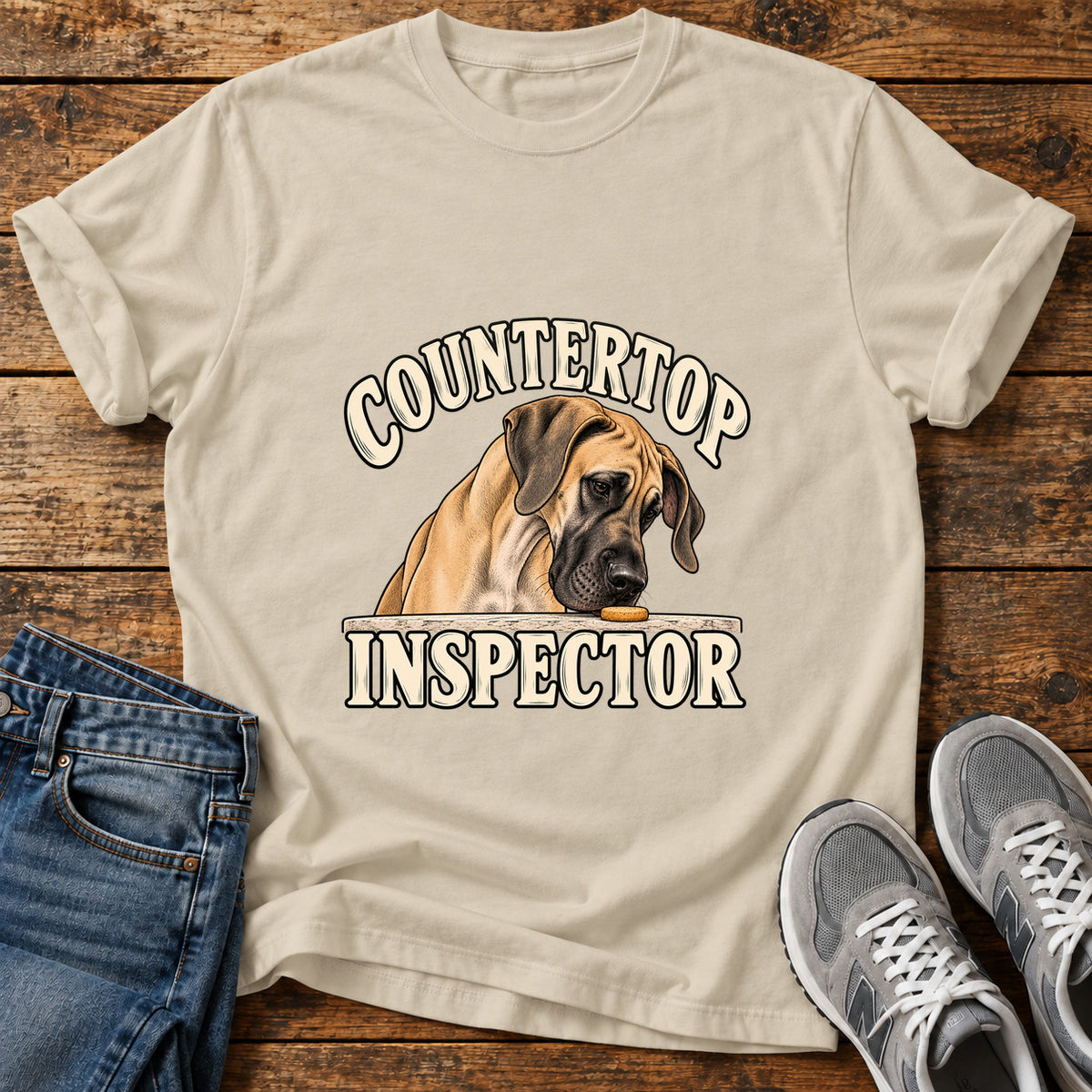 Countertop Inspector Great Dane graphic T-shirt in Sand, shown on a flat-lay shirt mockup
