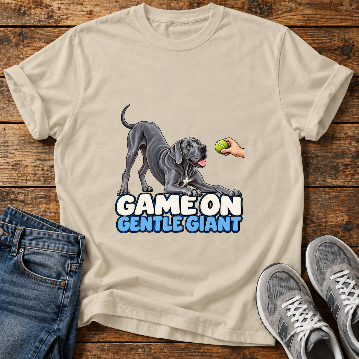 Game On Giant Great Dane graphic T-shirt in Sand, shown on a flat-lay shirt mockup
