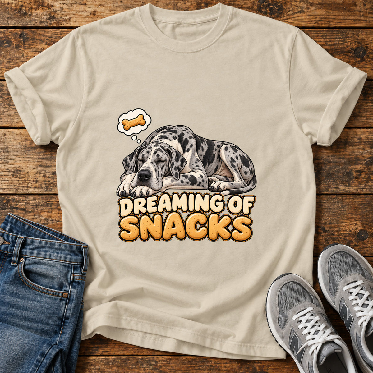 Dreaming Snacks Great Dane graphic T-shirt in Sand, shown on a flat-lay shirt mockup