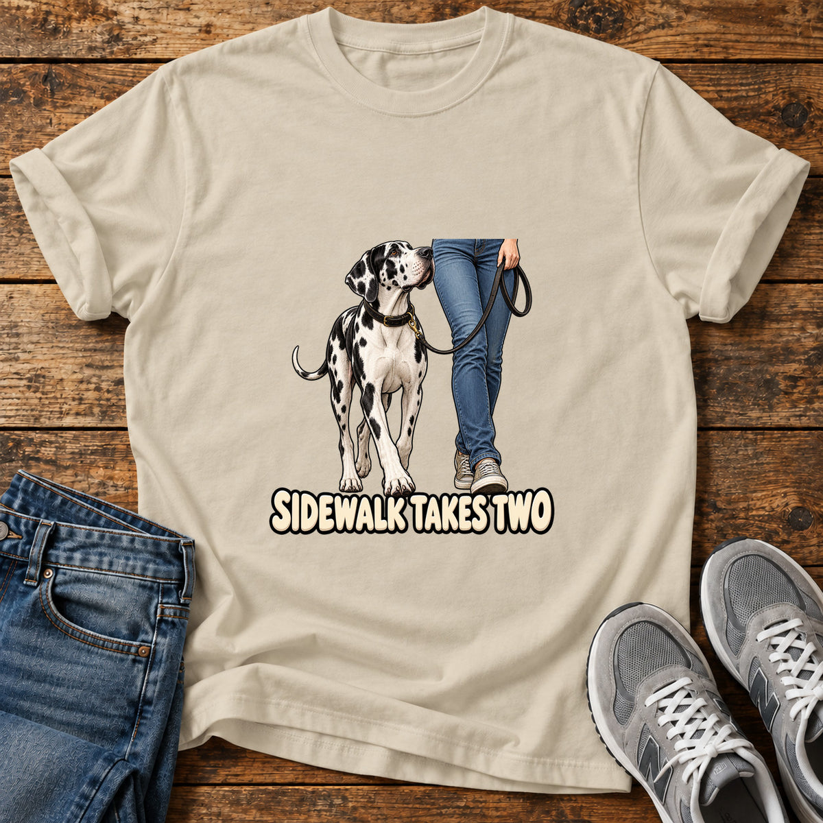Sidewalk Takes Two Great Dane graphic T-shirt in Sand, shown on a flat-lay shirt mockup