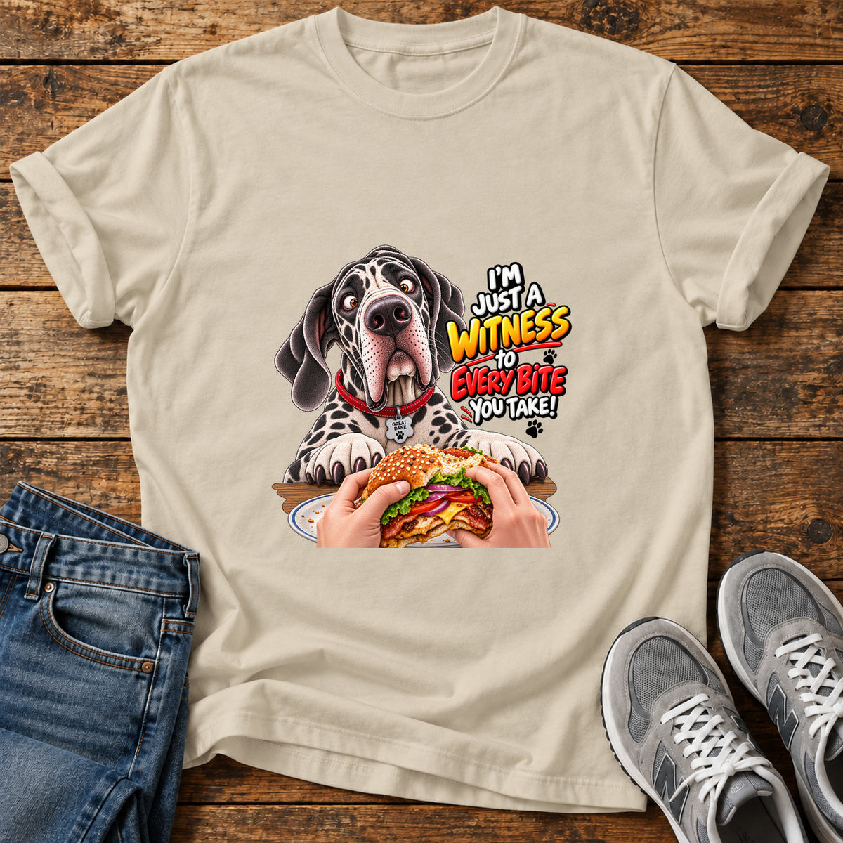 Witness Every Bite Great Dane graphic T-shirt in Sand, shown on a flat-lay shirt mockup
