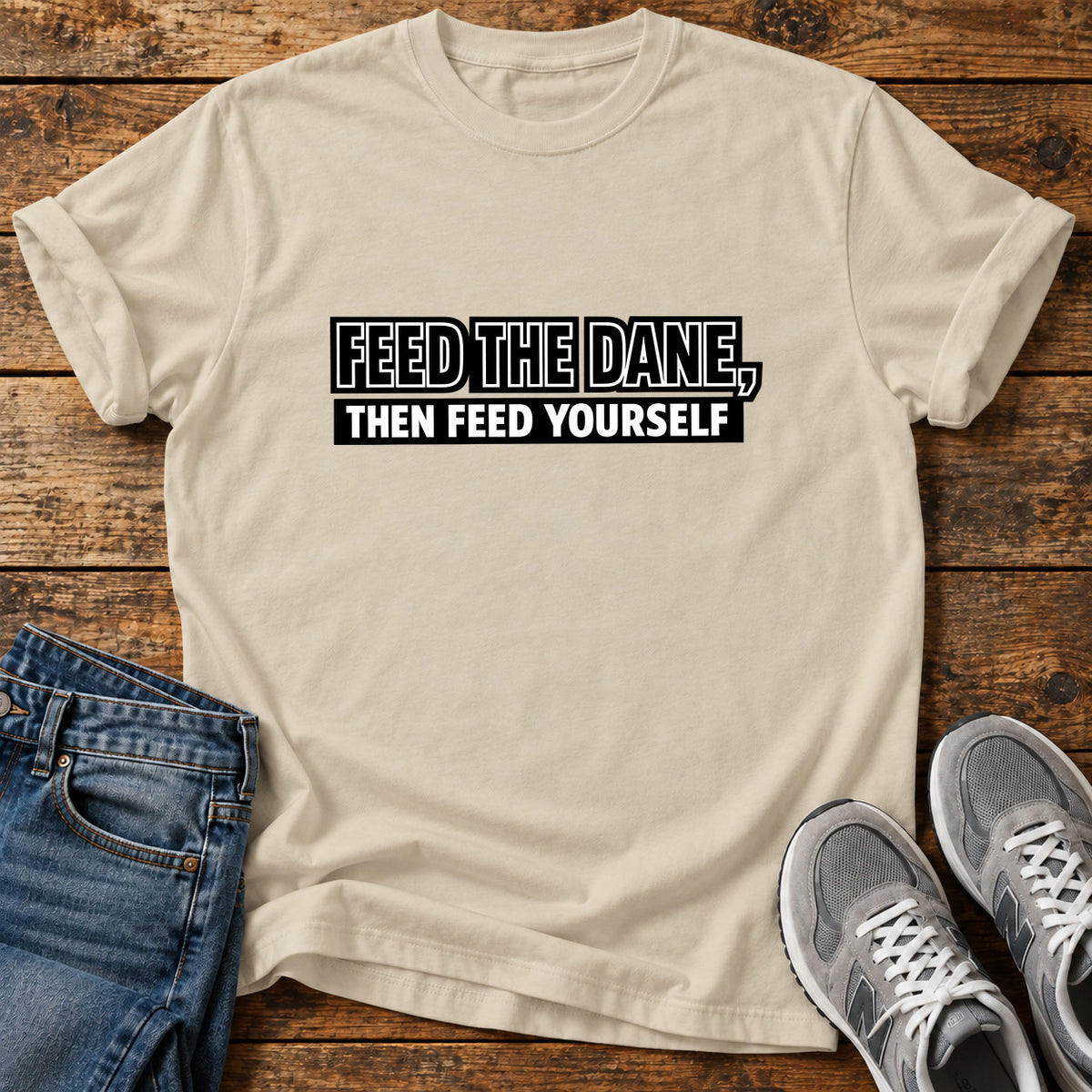 Feed The Dane Great Dane graphic T-shirt in Sand, shown on a flat-lay shirt mockup