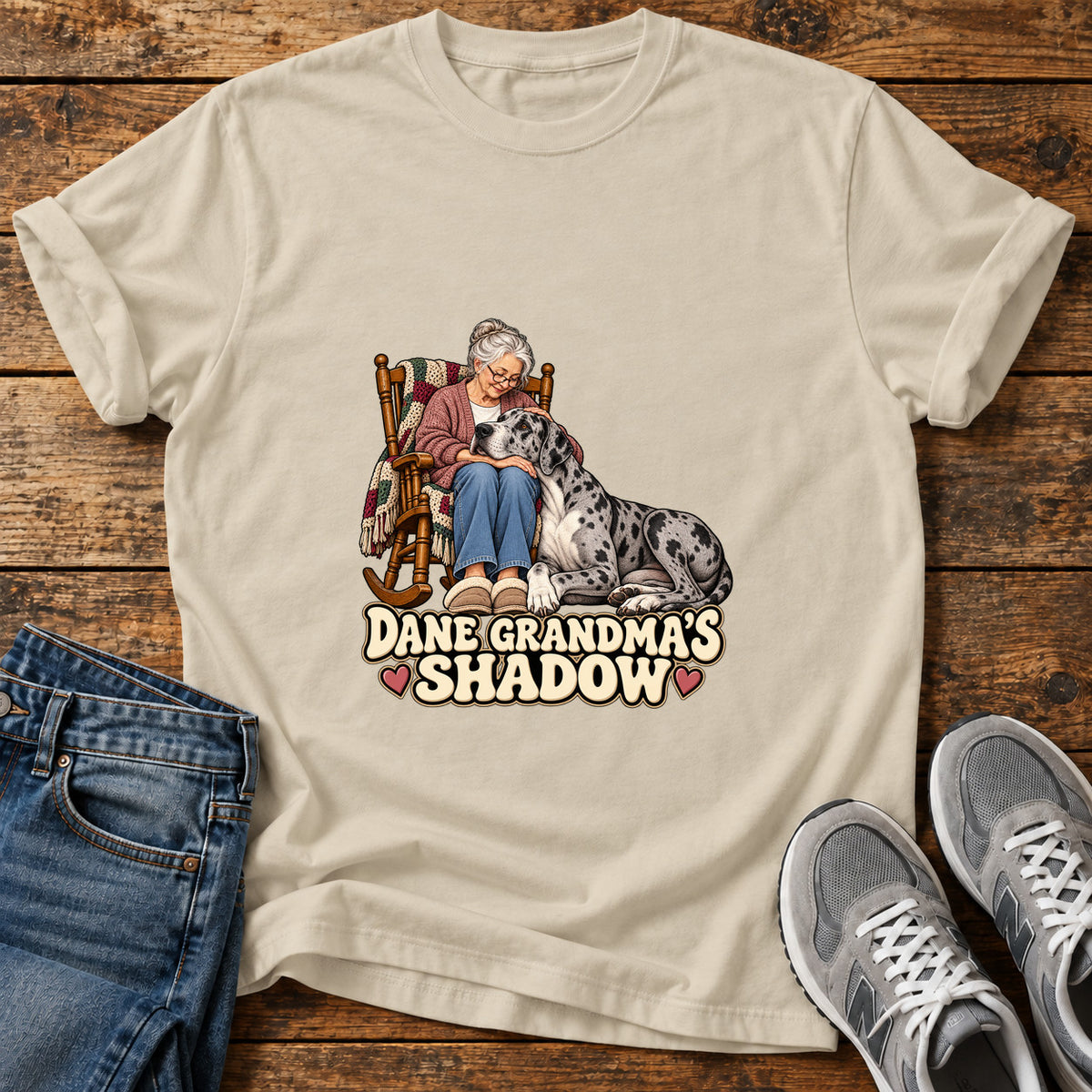Dane Grandma's Shadow Great Dane graphic T-shirt in Sand, shown on a flat-lay shirt mockup
