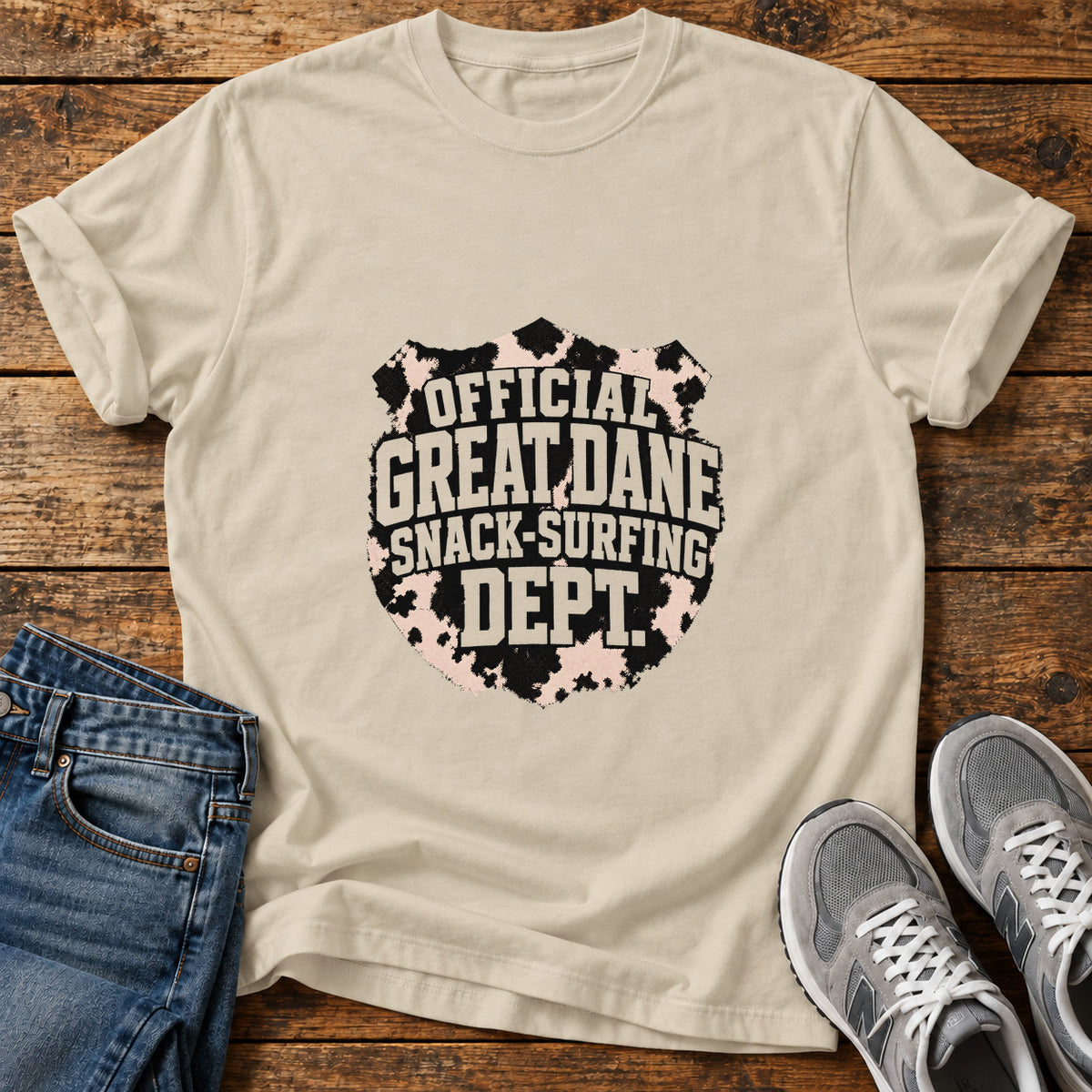 Snack-Surfing Dept Great Dane graphic T-shirt in Sand, shown on a flat-lay shirt mockup