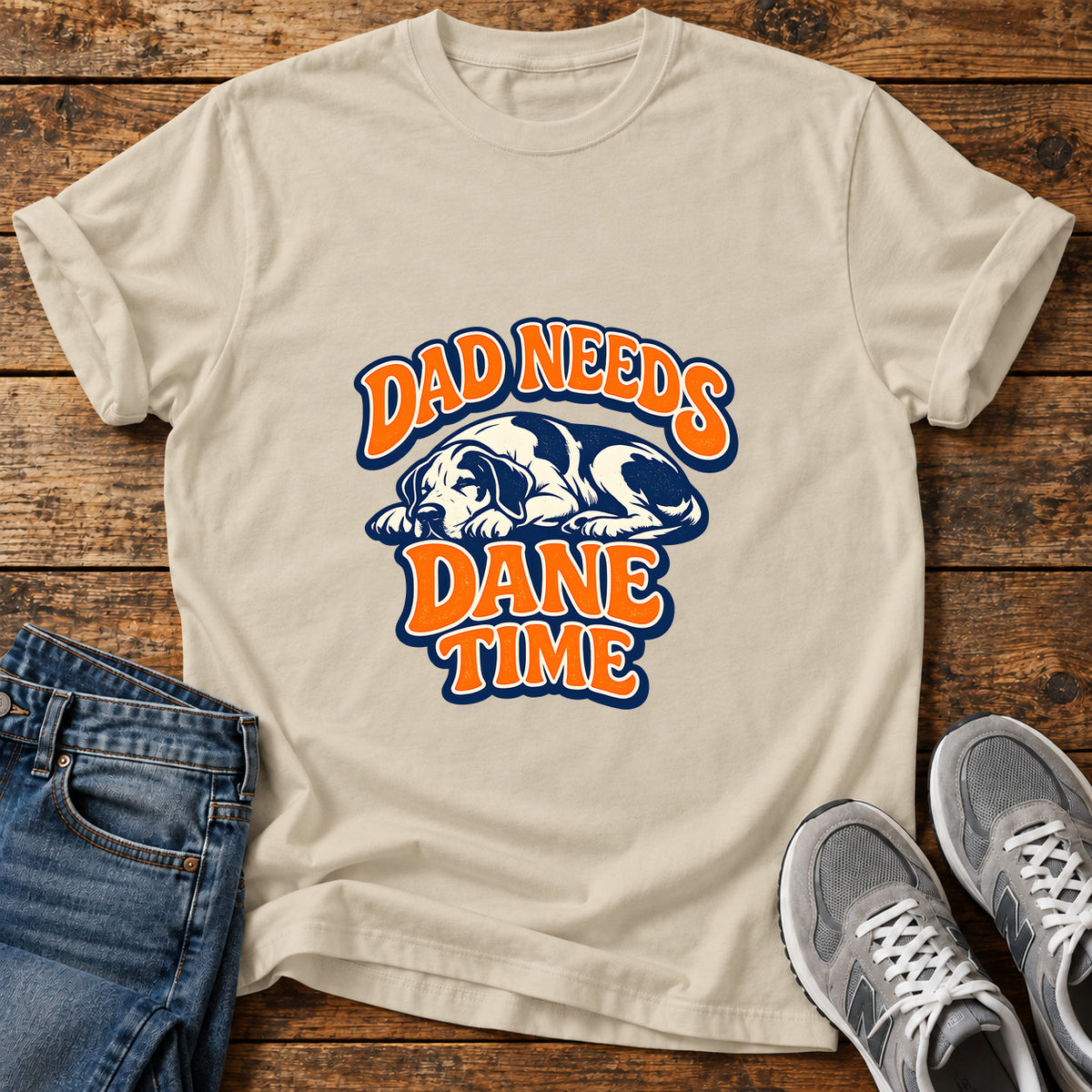 Dad Needs Dane Great Dane graphic T-shirt in Sand, shown on a flat-lay shirt mockup