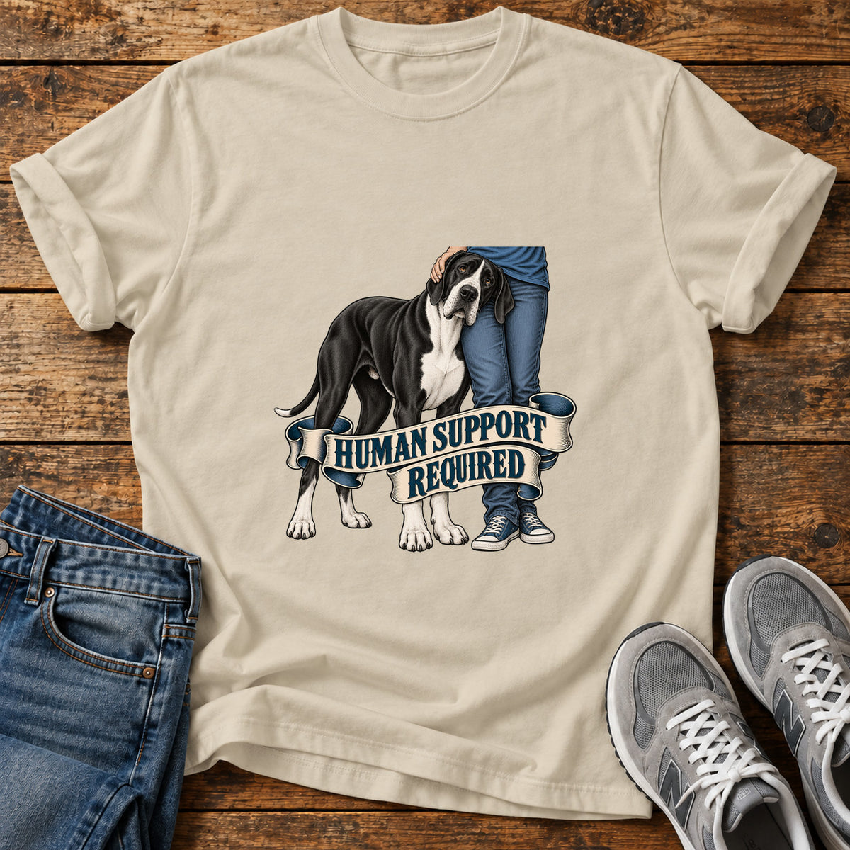 Human Support Required Great Dane graphic T-shirt in Sand, shown on a flat-lay shirt mockup
