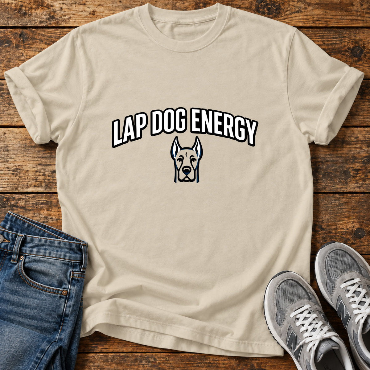 Lap Dog Energy Great Dane graphic T-shirt in Sand, shown on a flat-lay shirt mockup