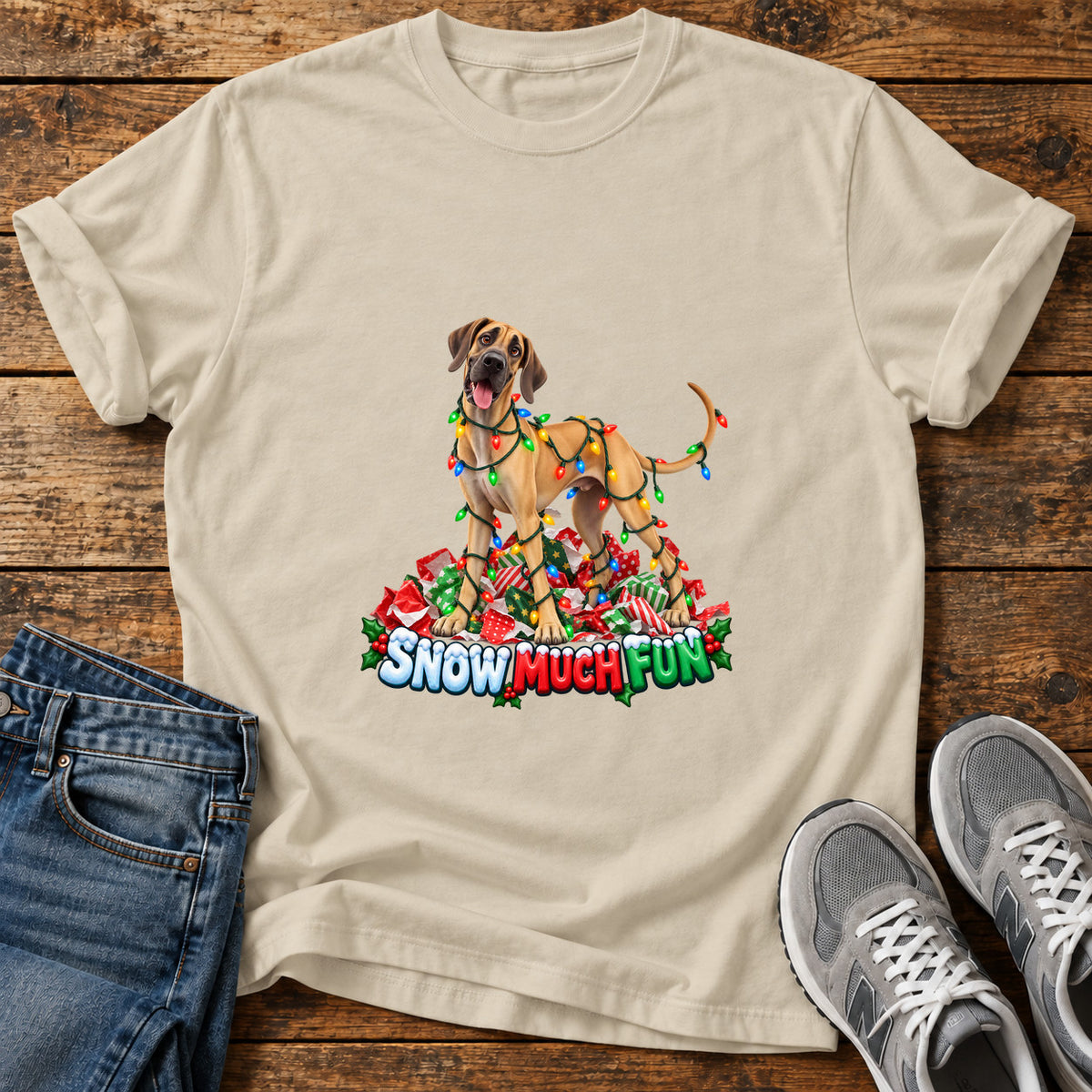 Snow Much Fun Great Dane graphic T-shirt in Sand, shown on a flat-lay shirt mockup